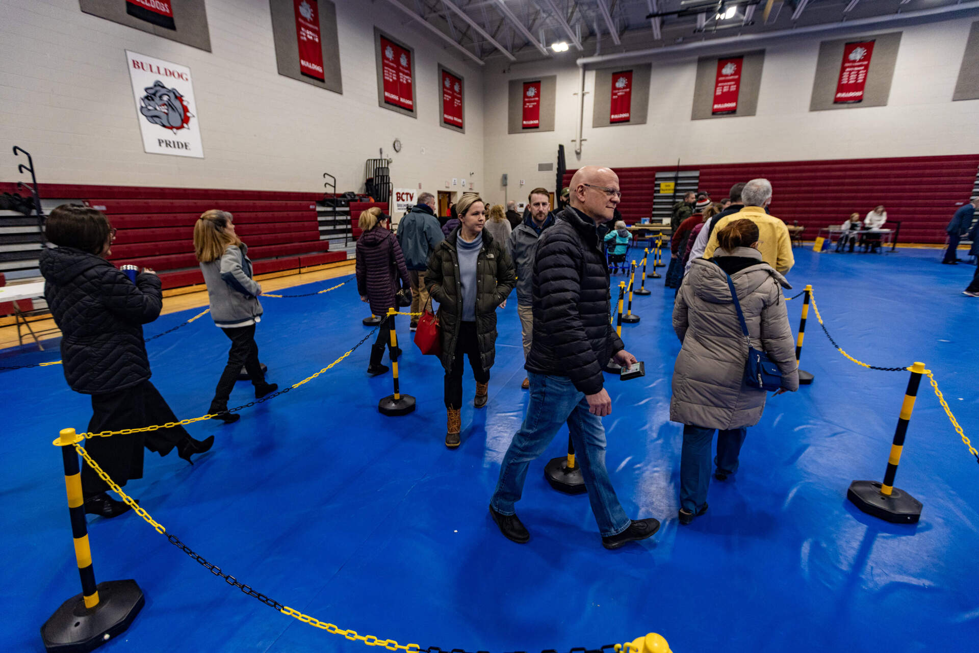 Voters at Bedford High School walk through ropes in line to collect their ballots to vote. (Jesse Costa/WBUR)