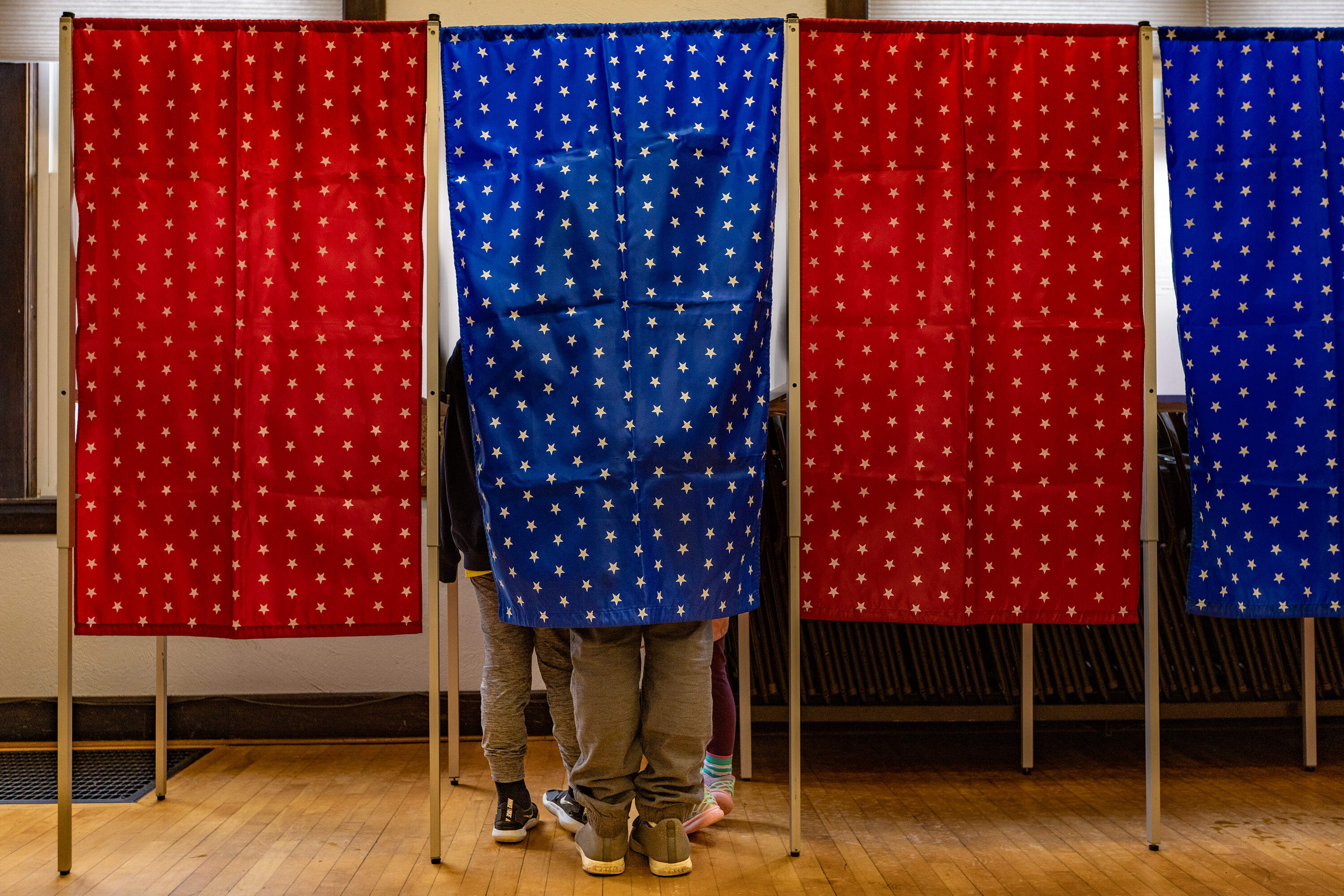 Brian Johnson and his children Reid, 9, and Sage, “Almost seven,” vote together at Newfields Town Hall during the New Hampshire Primary. (Jesse Costa/WBUR)
