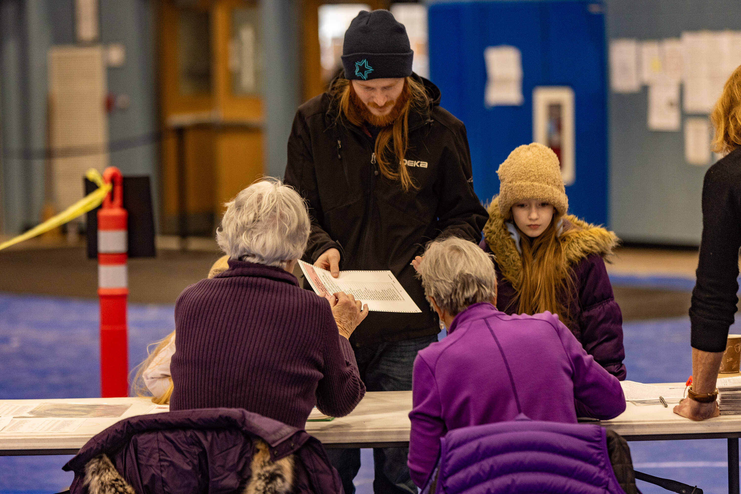 A voter receives his ballot to vote at Oyster River High School in Durham. (Jesse Costa/WBUR)