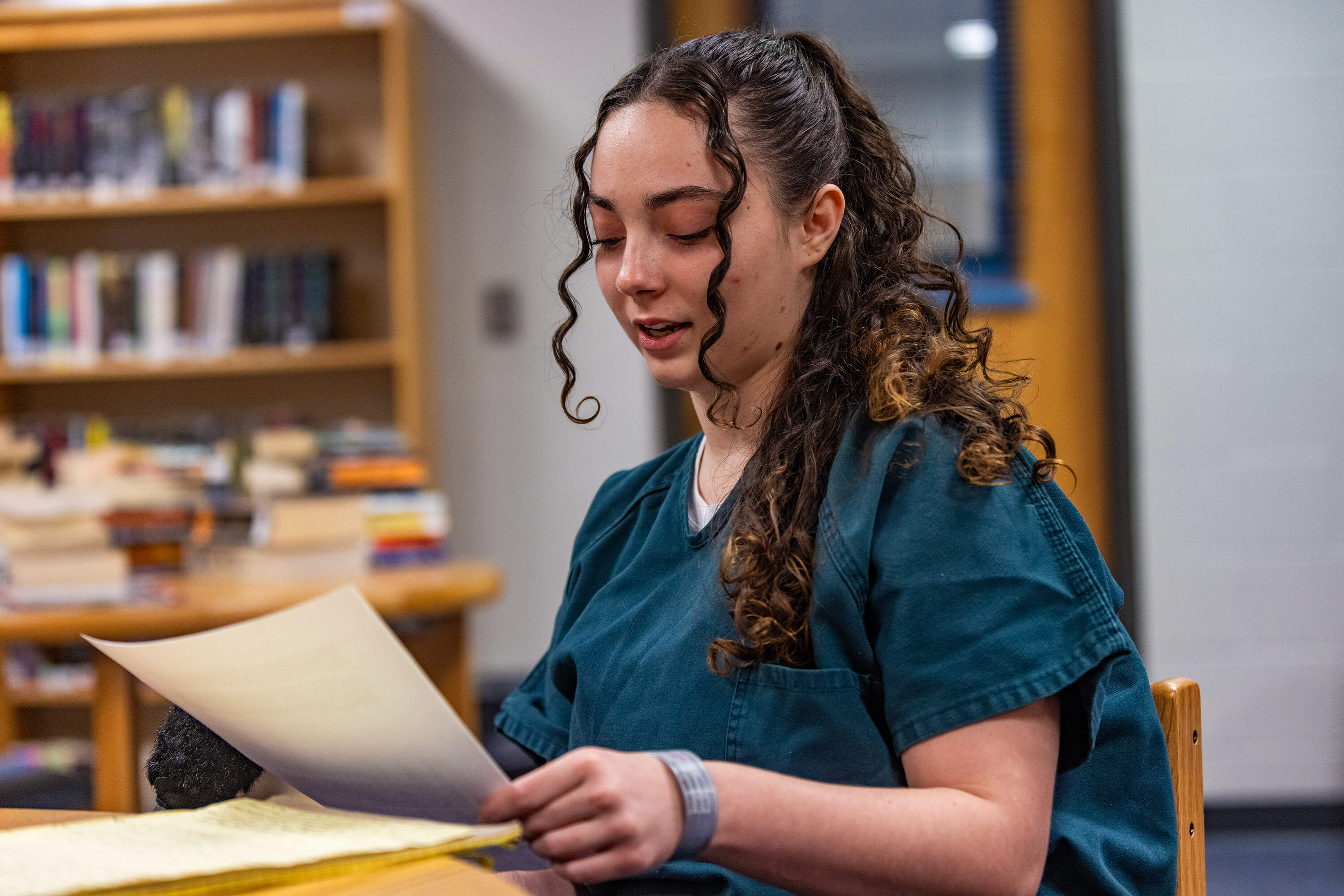 Tianna Hutchinson reads from a list she has compiled of the books she has read while being held at Barnstable County Correctional Facility. (Jesse Costa/WBUR)