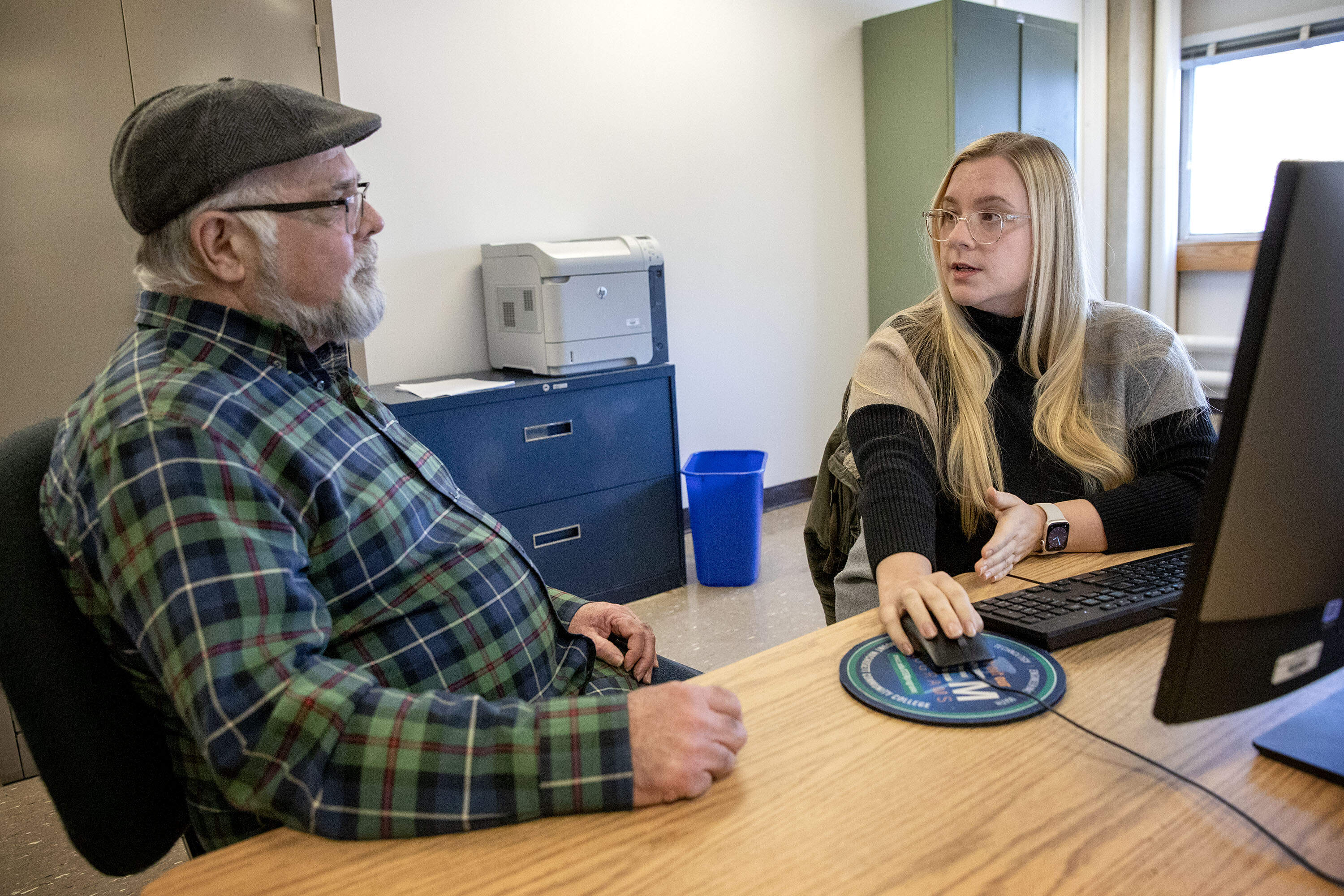 Mount Wachusett Community College community outreach counselor Cassie Peltola talks with film student K.C. Hayes about his financial aid. (Robin Lubbock/WBUR)