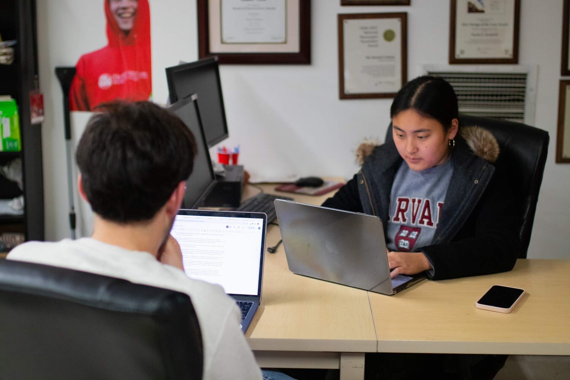 Claire Yuan, co-associate managing editor for the Crimson, works across Miles Herszenhorn inside the Crimson offices in December 2023. (Courtesy The Harvard Crimson)