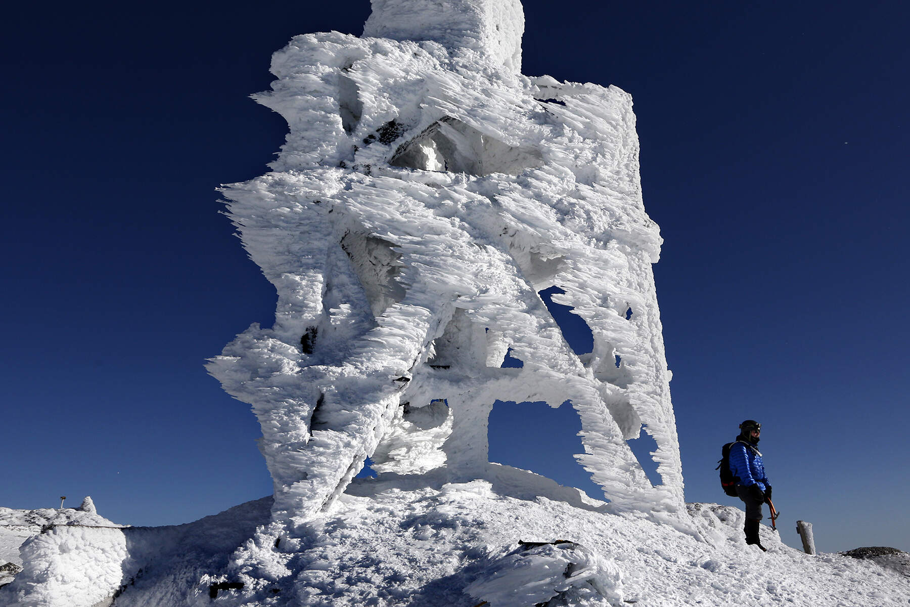 Douglas Ciampi of Westminster, Mass., stands next to a rime ice-covered antenna while taking in the view from the summit of Mount Washington, N.H., Sunday, Feb. 23, 2020. Rime ice forms when supercooled moisture hits a solid surface. Ciampi's 5-hour hike was rewarded by exceptionally clear conditions allowing for a visibility of 100 miles from the northeast's highest peak. (Robert F. Bukaty/AP)
