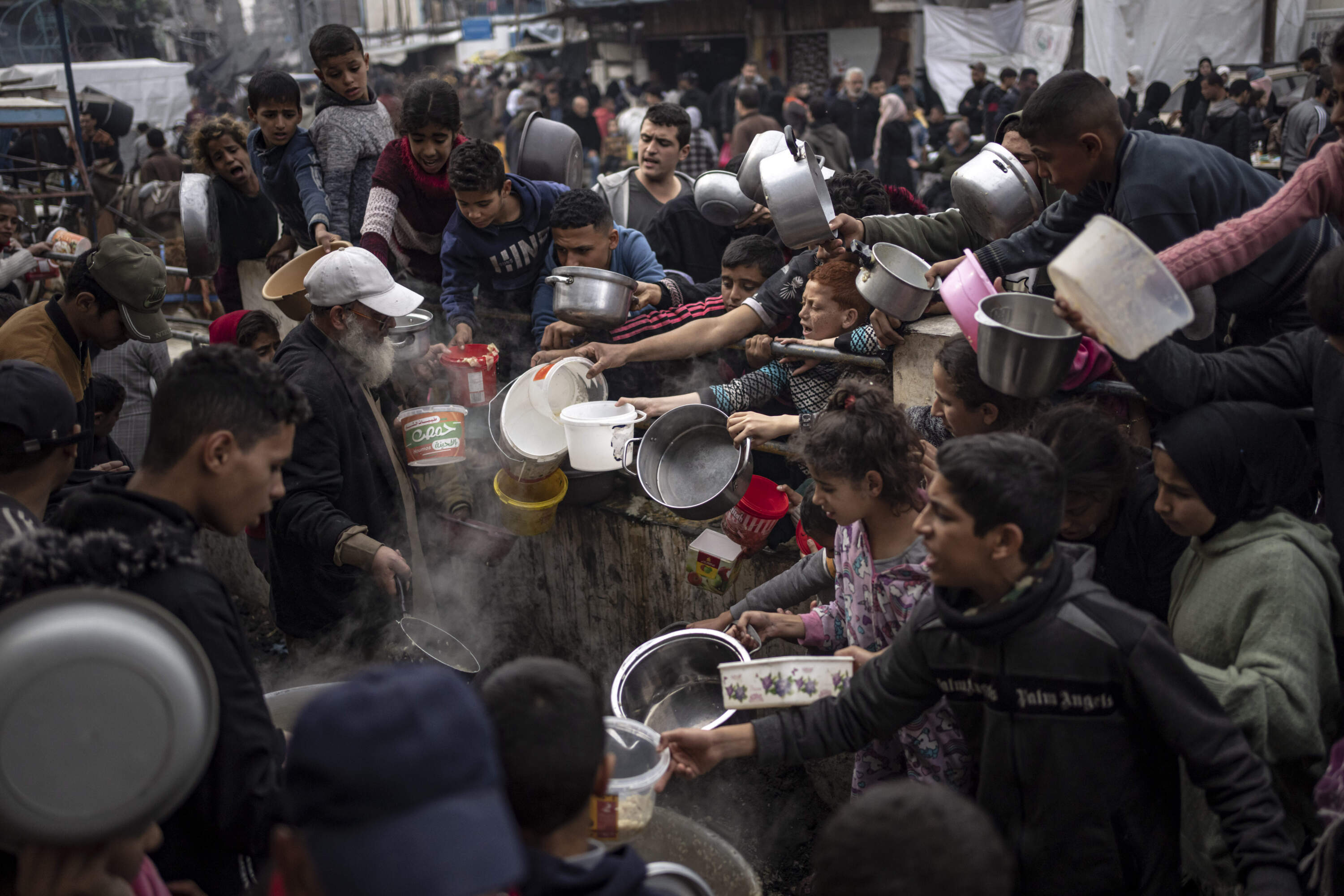 Palestinians line up for a free meal in Rafah, Gaza Strip. International aid agencies say Gaza is suffering from shortages of food, medicine and other basic supplies as a result of the two and a half month war between Israel and Hamas. (Fatima Shbair/AP)