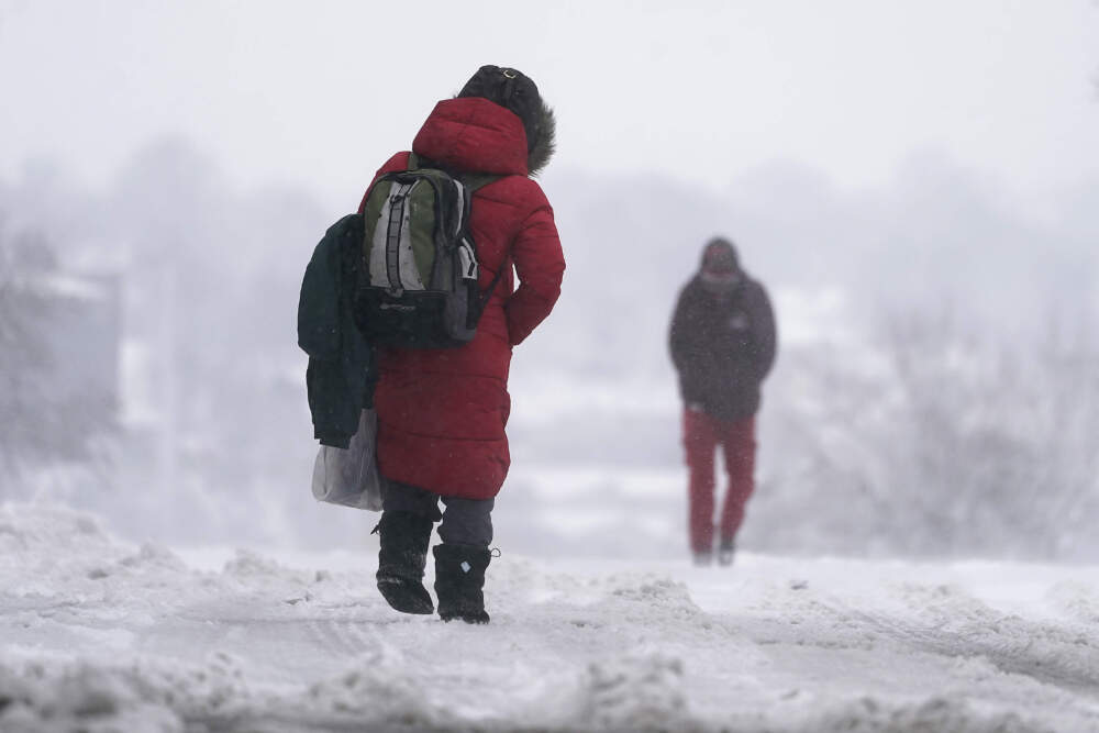 People walk down a snow-packed street as a winter storm moved through the region in Kansas City, Missouri. (Charlie Riedel/AP)