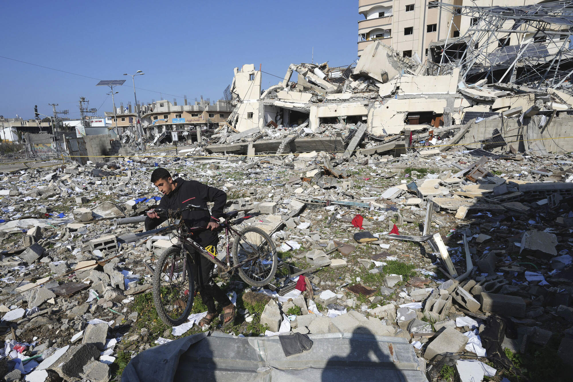 A Palestinian walks through the destruction by the Israeli bombardment in the Nusseirat refugee camp in Gaza Strip. (Adel Hana/AP)