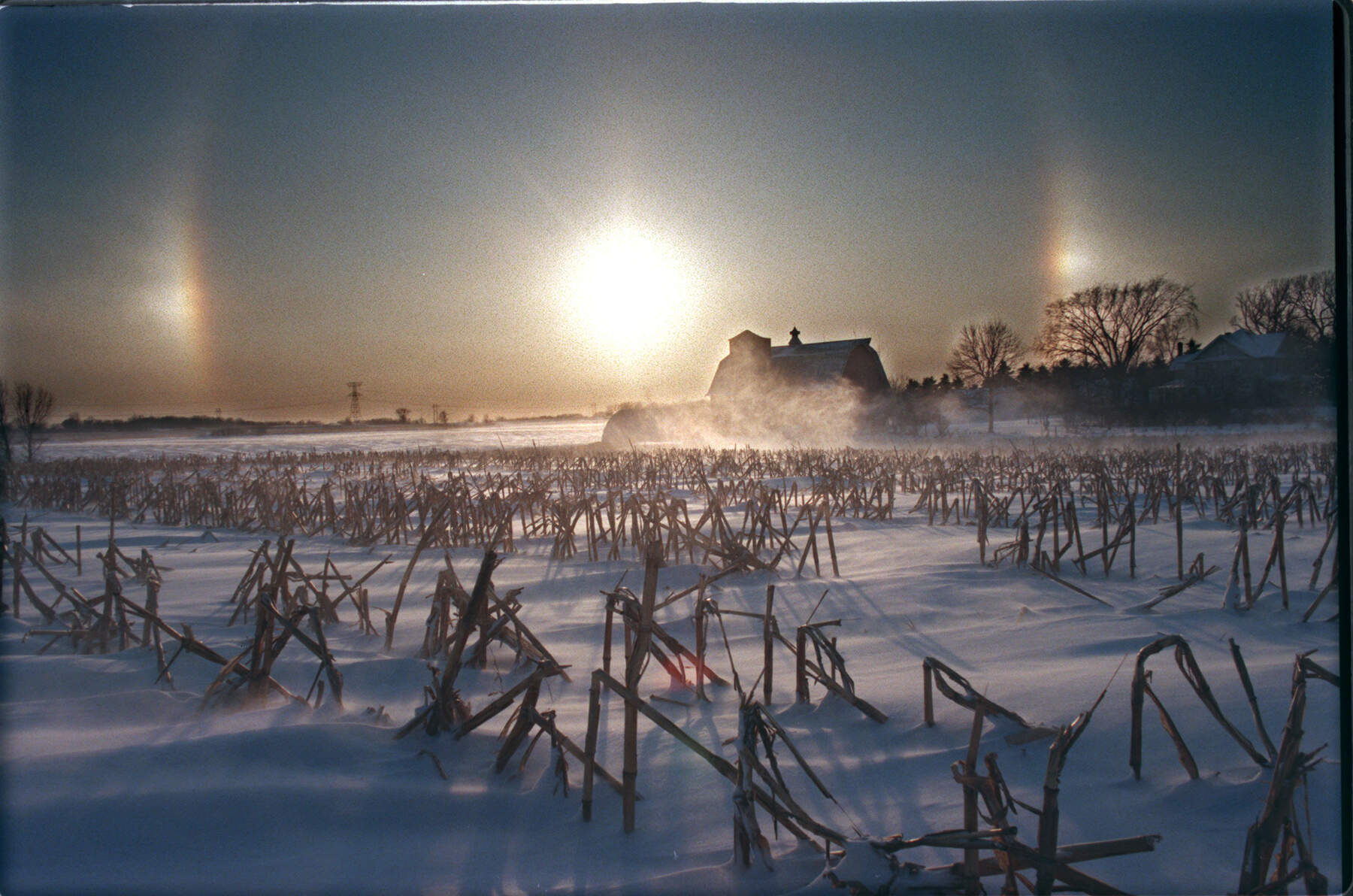 Sundogs bracketed the setting sun as the wind whipped up snow on a frozen corn field in Minnesota. (Photo By DAVID BREWSTER/Star Tribune via Getty Images)