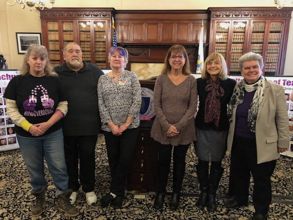 Laurie MacDougall, Gary Carter, Lynn Wencus, Cheryl Juaire, Maryanne Frangules and Rep. Kate Donaghue are parents and members of a statewide coalition calling for Mass. to open overdose prevention centers. (Martha Bebinger/WBUR)