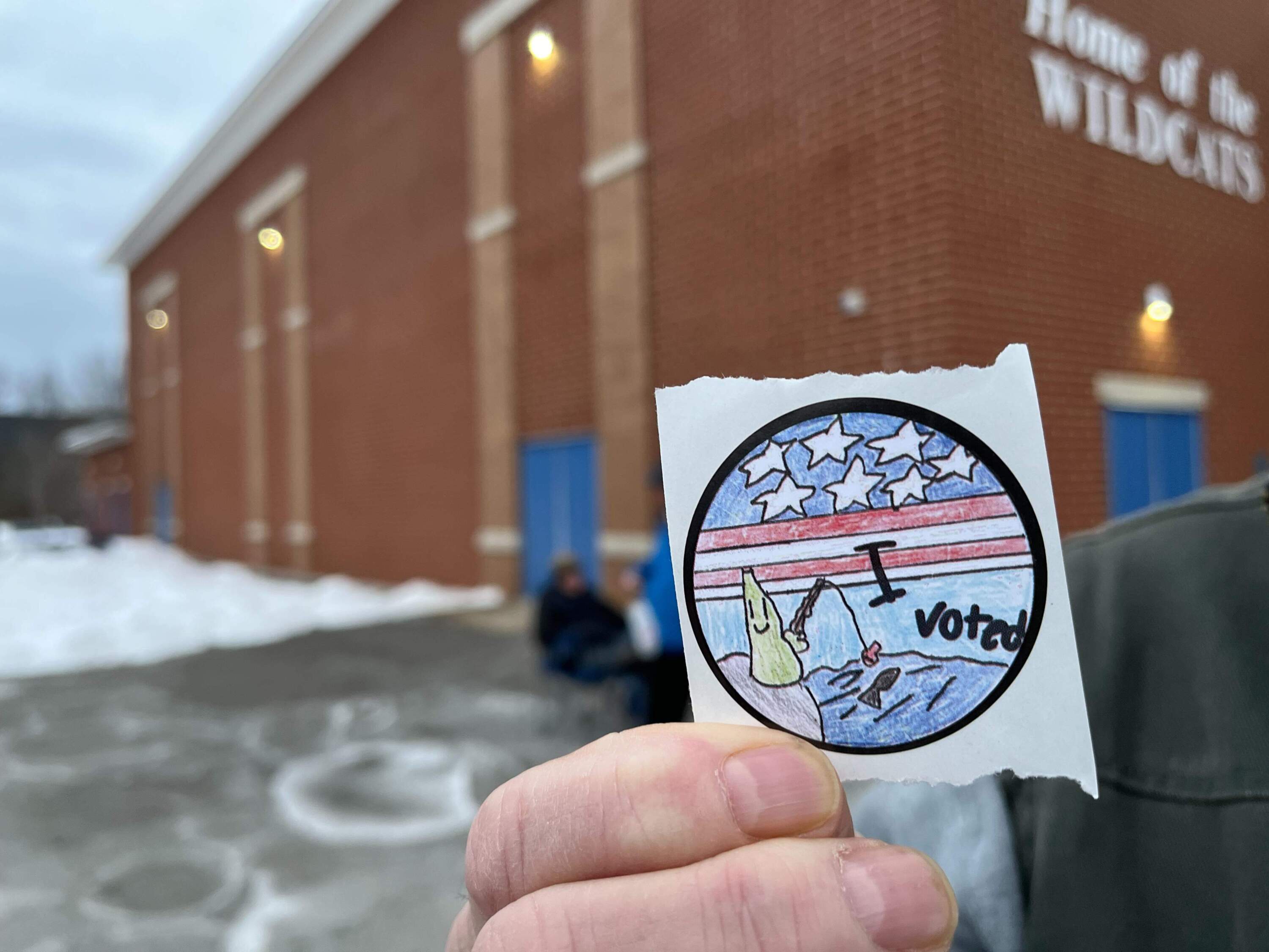 A voter in Weare holds up one of the state's new 