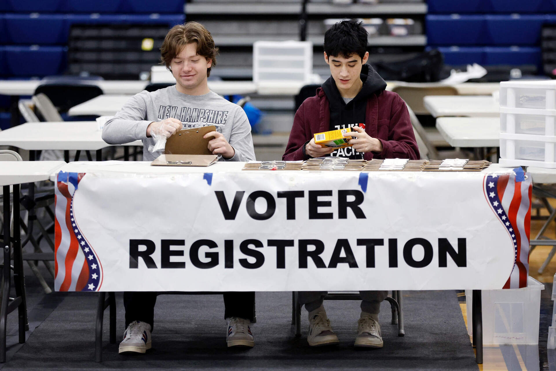 High school students Sawyer Brockman, left, and Jack Skilling volunteer at the voter registration table for the presidential primary election at Windham High School. (Michael Dwyer/AP)