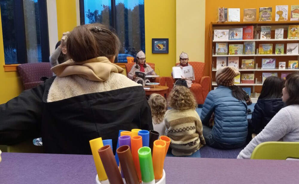 A crowd at the public library in Hadley, Massachusetts, listen as Emma and Belley Barrett read from their new book, “Sister Detectives.” (Jill Kaufman/NEPM)