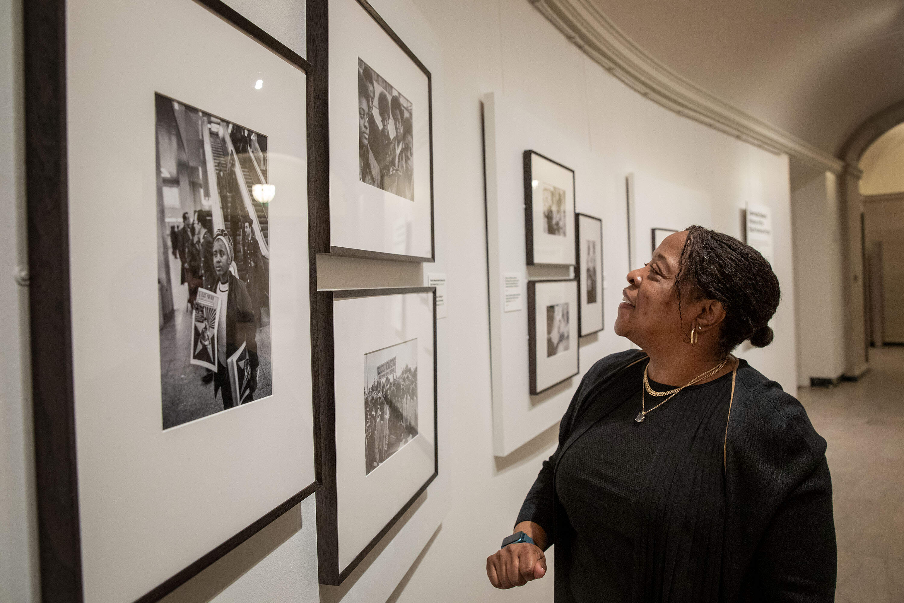 Gail Jones looks at a 1970 photograph by Stephen Shames of herself with her siblings and two friends, in the MFA Boston's