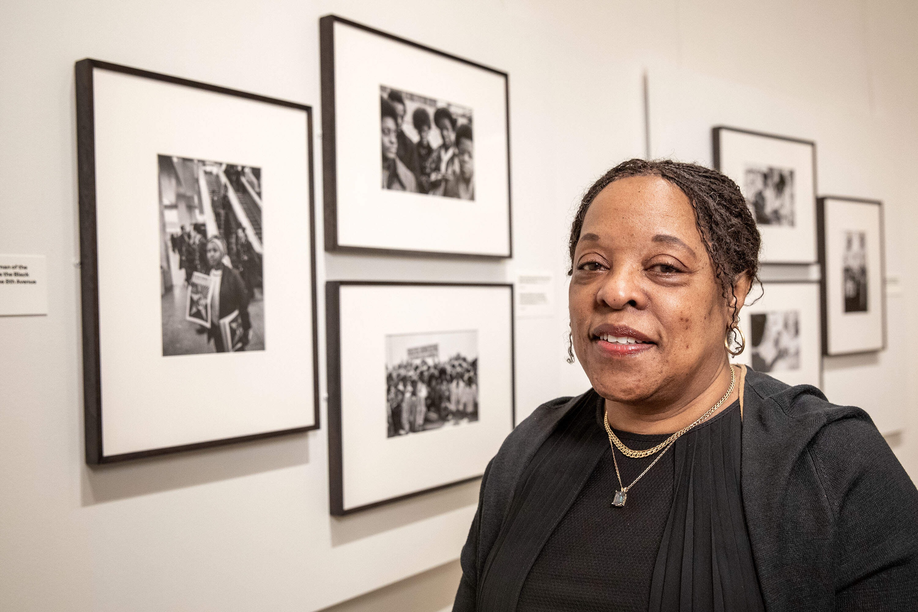 Gail Jones standing by a 1970 photograph by Stephen Shames of herself with her siblings and two friends, in the MFA Boston's