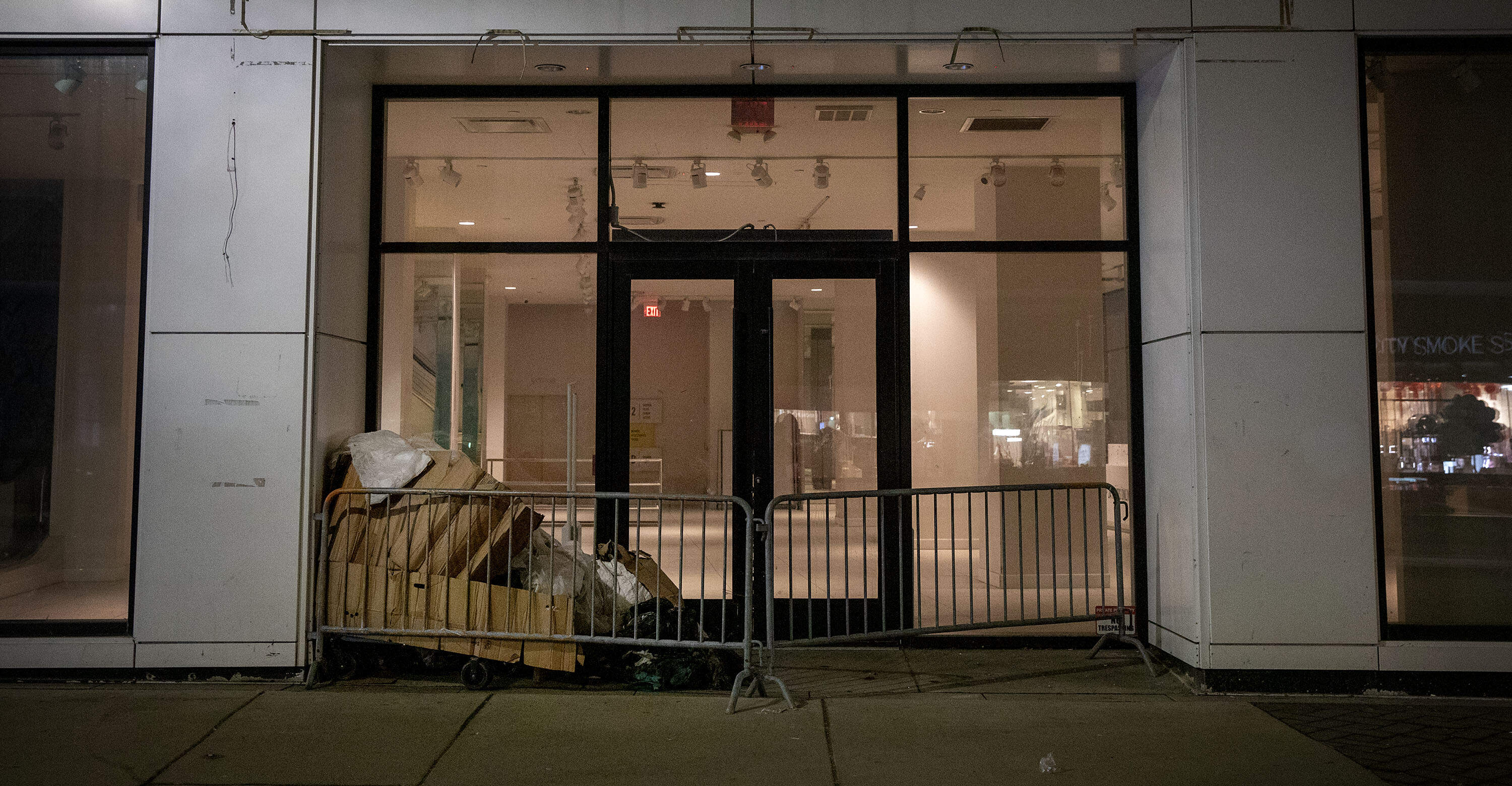 Cardboard and paper cover a person sleeping in a doorway near Downtown Crossing. A homeless census team stopped to offer the person help. (Robin Lubbock/WBUR)