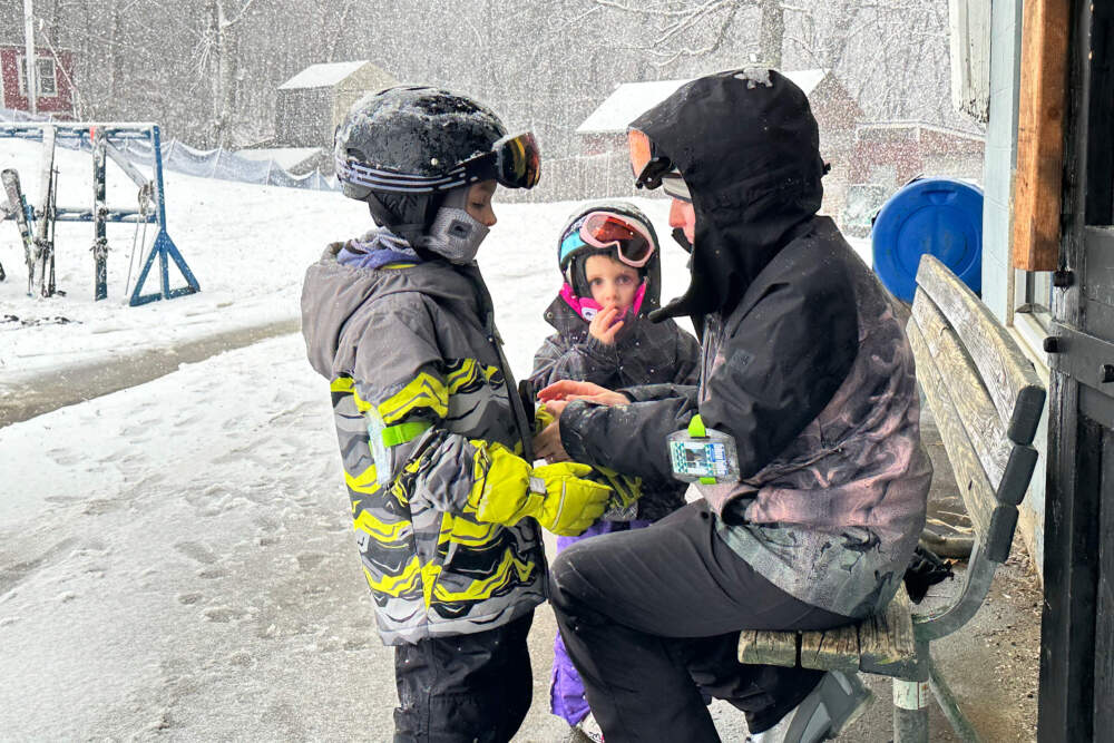 Crystal Soule of Waltham helps her kids, Elodie, middle, and Jackson get prepared for their next run down the Blue Hills. (Simon Rios/WBUR)