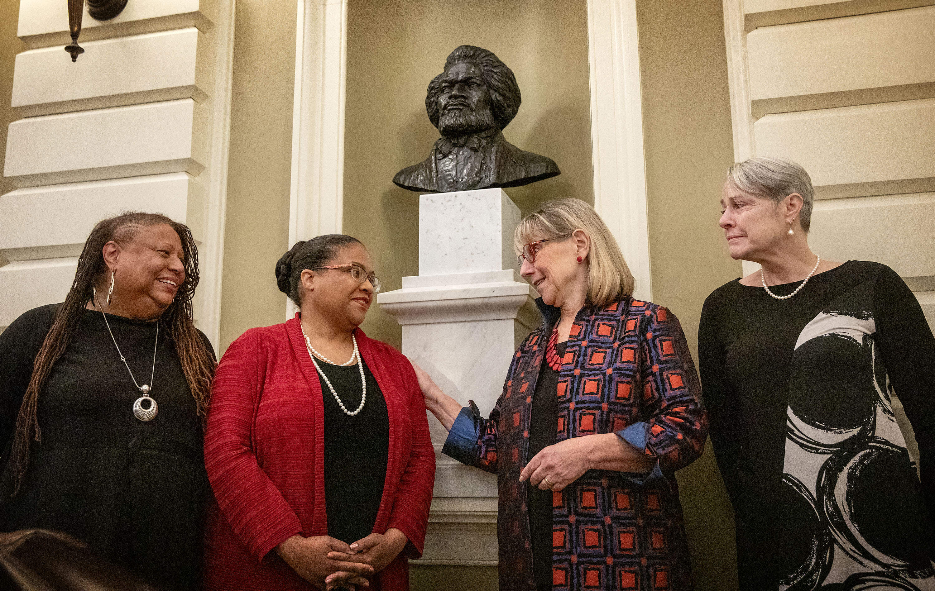 L’Merchie Frazier, Member of the State House Art Commission, Dr. Noelle Trent, President & CEO of the Museum of African American History, Senate President Karen Spilka and Nina Lillie LeDoyt, daughter of Artist Lloyd Lillie, at the unveiling of the bust of Frederick Douglass in the Massachusetts State House Senate Chamber. (Robin Lubbock/WBUR)