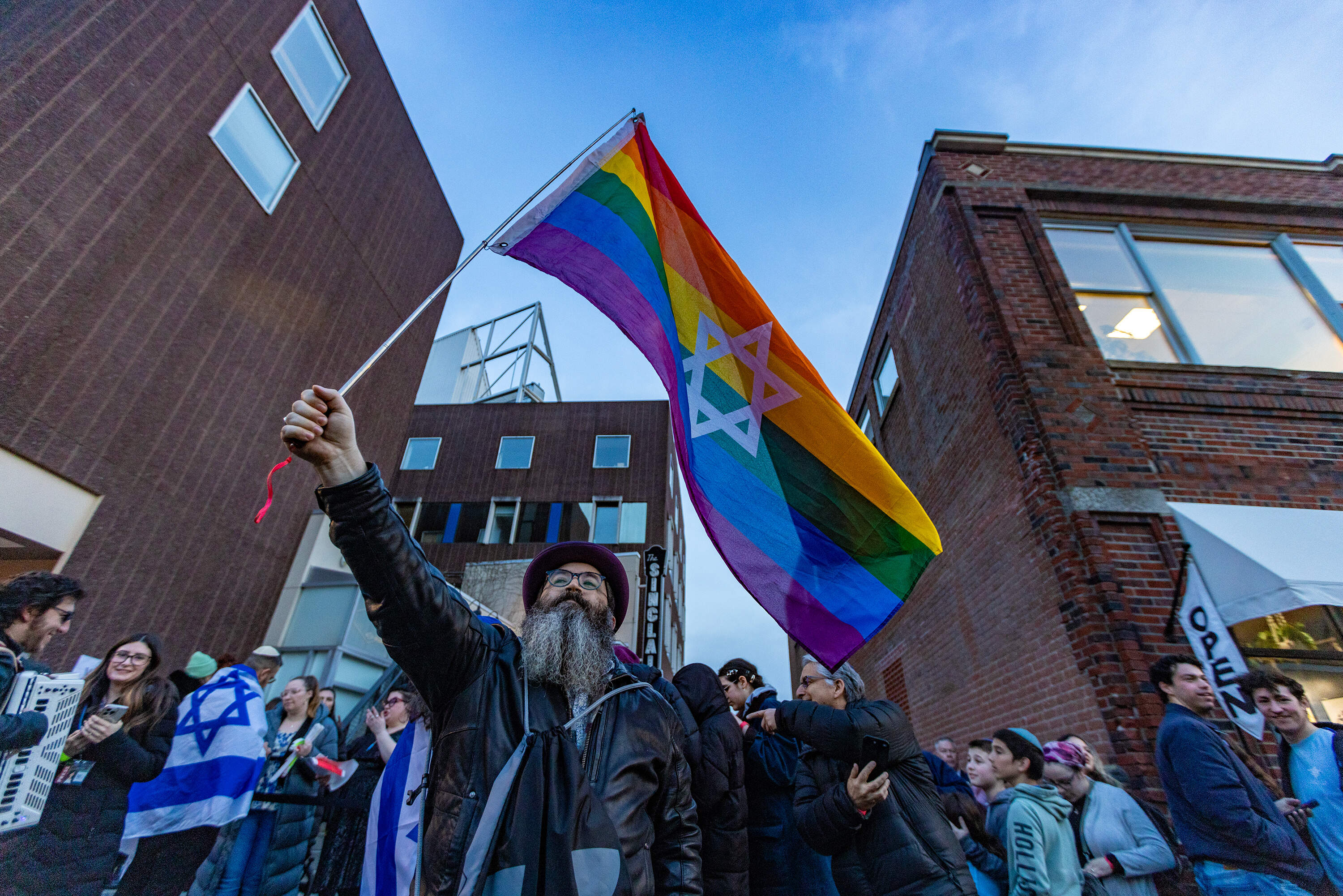 Dr. Ira Kirschner waves an Israeli flag outside The Sinclair in Cambridge before entering the Harvard Chabad concert. (Jesse Costa/WBUR)