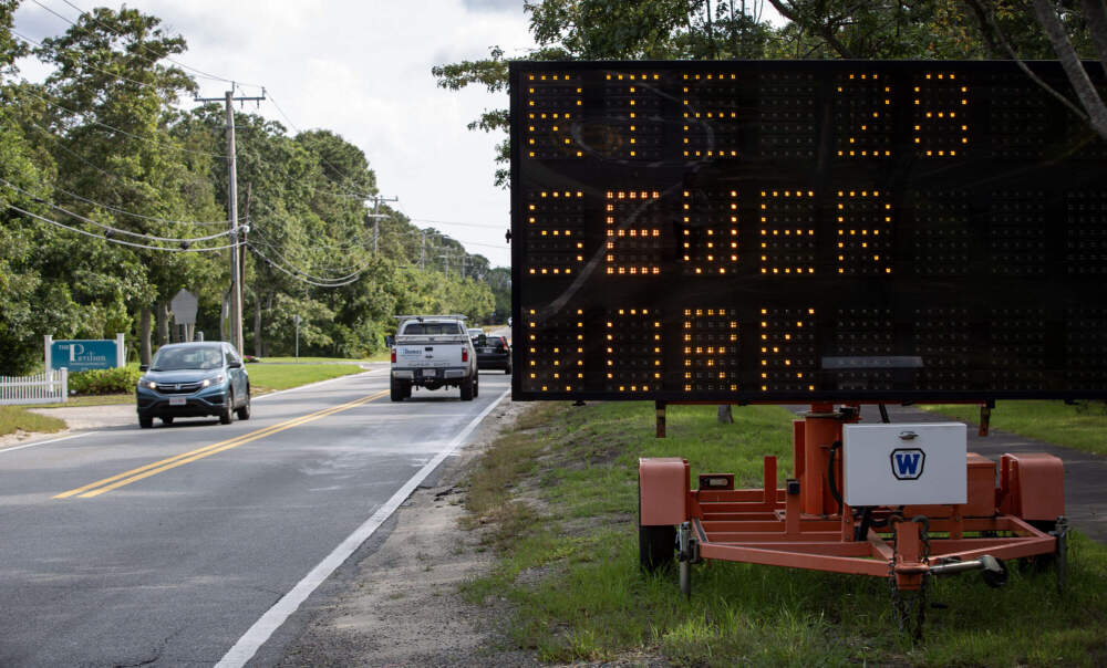 A sign on a busy Route 28 in Barnstable warns of ongoing construction work to lay sewer pipes. (Robin Lubbock/WBUR)