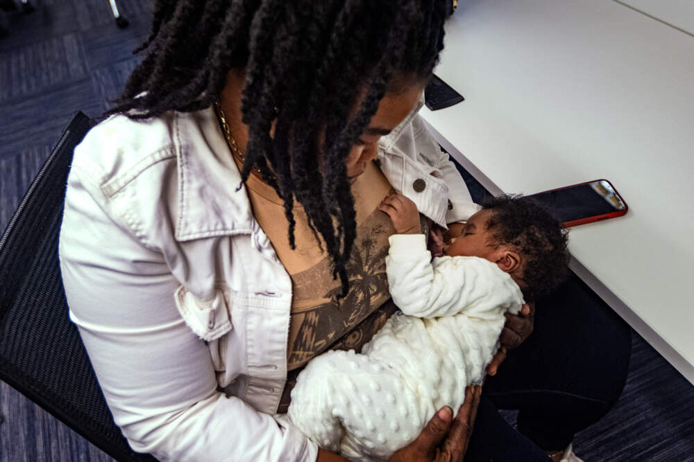 A Haitian migrant mother holds her newborn baby boy at the offices of the non-profit Heading Home. (Jesse Costa/WBUR)