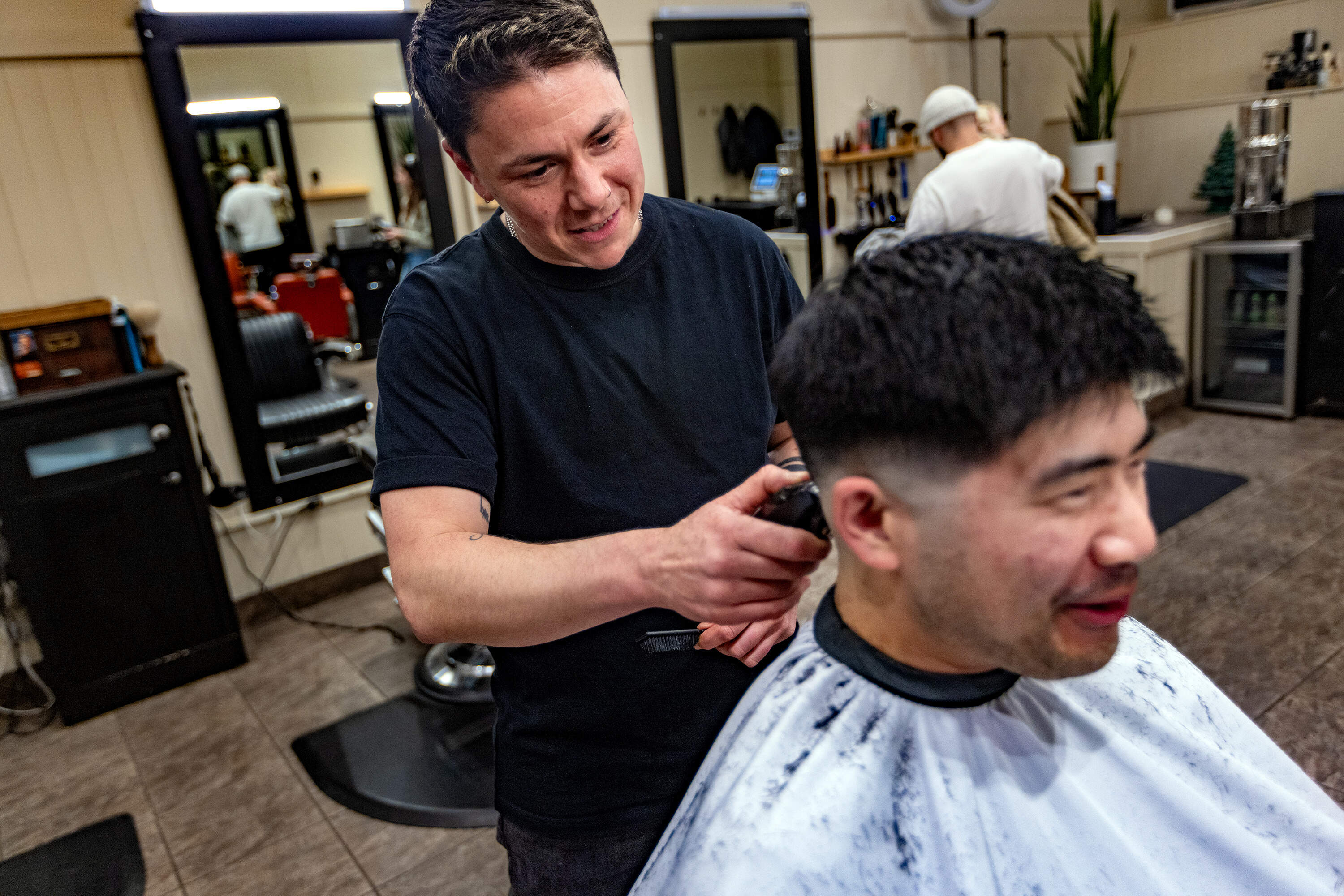 M Arida gives Aaron Chiou his usual trim. (Jesse Costa/WBUR)