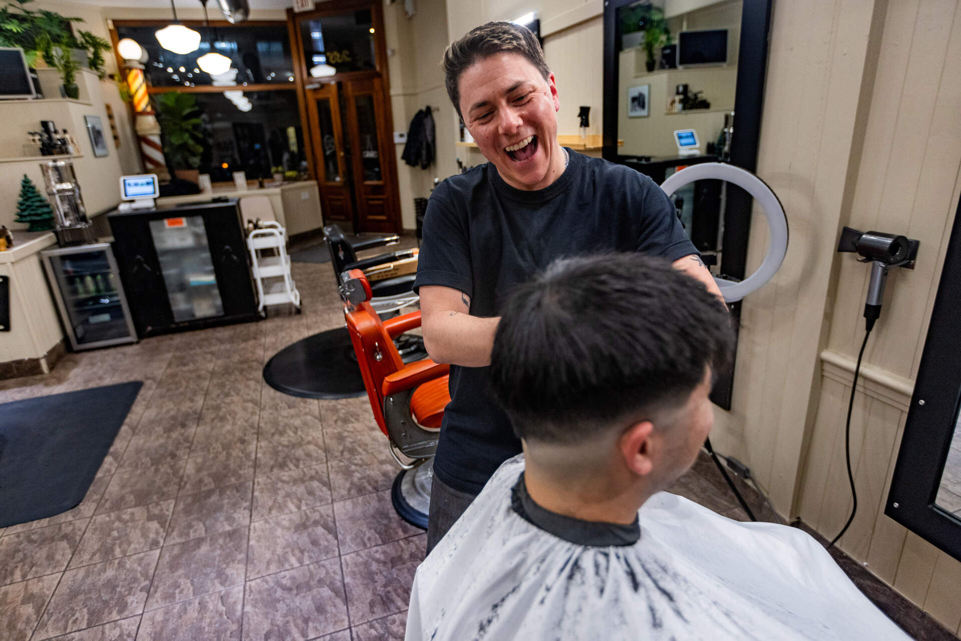 M Arida gets to work cutting Aaron Chiou's hair. (Jesse Costa/WBUR)