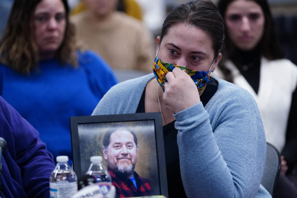 Rachael Sloat, fiance of victim Peyton Brewer Ross, in framed photo, testifies during a hearing of the independent commission investigating the law enforcement response to the mass shooting in Lewiston, Maine. (Robert F. Bukaty/AP)