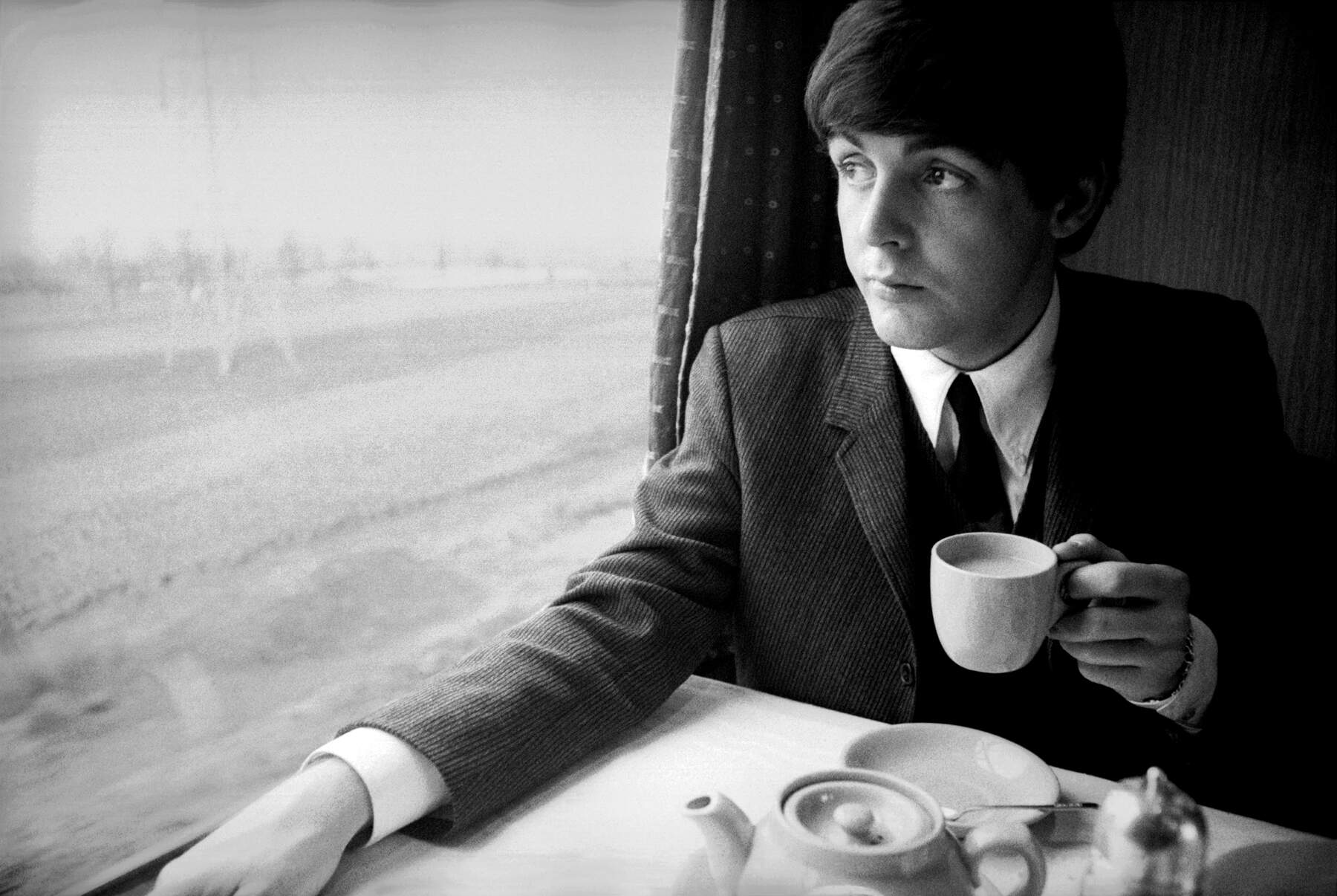 Paul McCartney on a train in 1964. (Harry Benson)