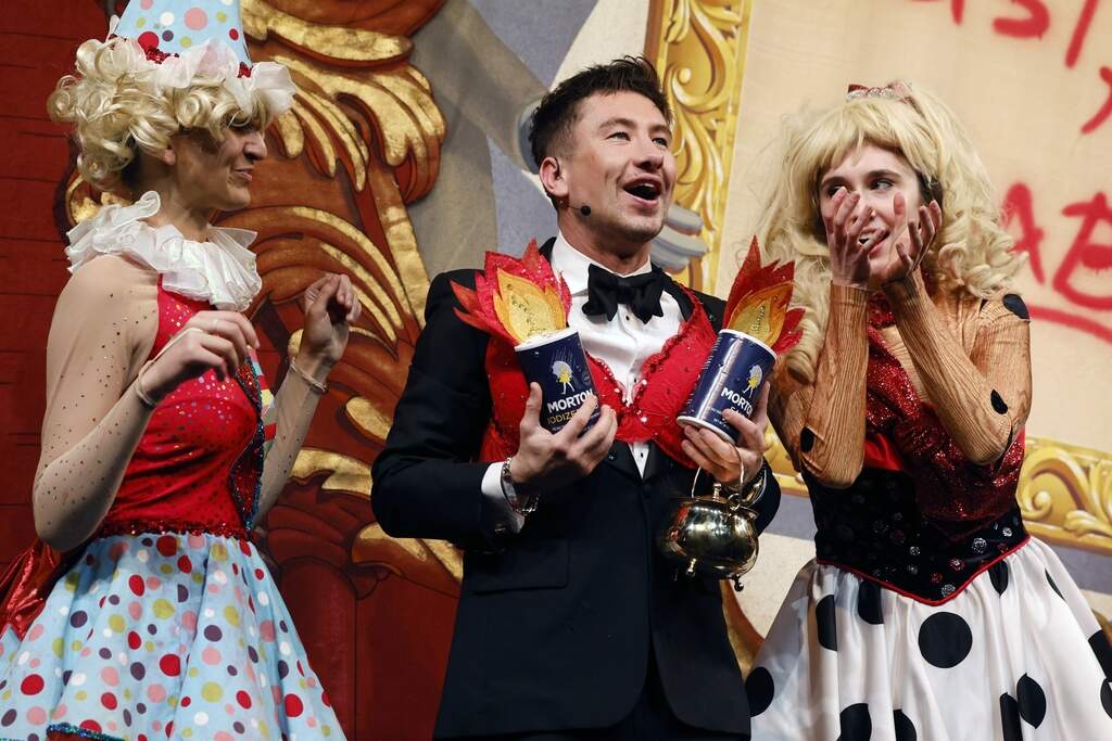 Barry Keoghan, center, wears a bra adorned with salt shakers while holding the Pudding Pot. (Michael Dwyer/AP)