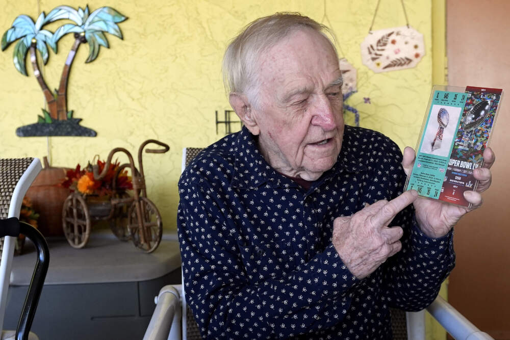 Tom Henschel holds up tickets to quarterback Tom Brady's first and last Super Bowl games during an interview at his home in Tampa, Fla. (Chris O'Meara/AP)