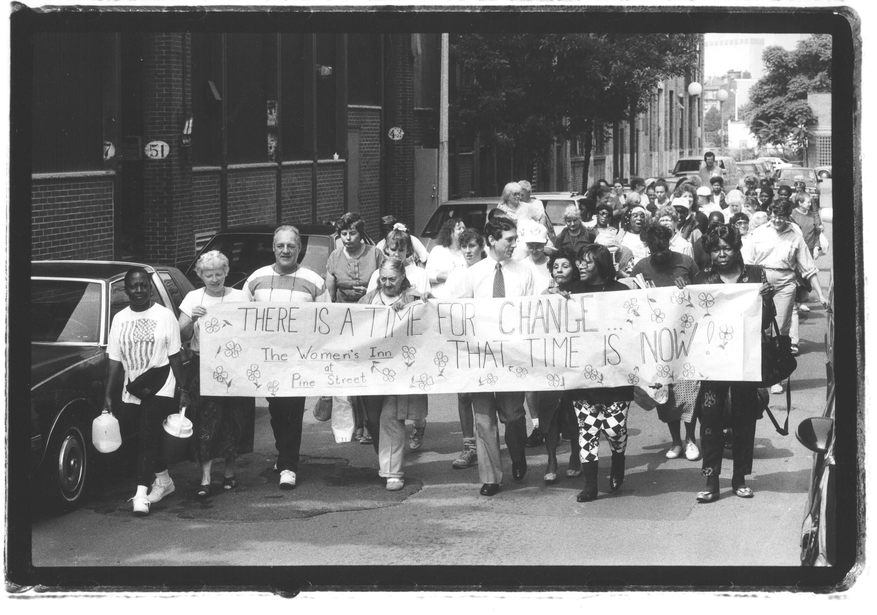 Sandra Jones-Hansen stands second from the right (in checkered pants) holding a sign during a march held ahead of the opening of the Pine Street women’s shelter in the early 1980s. (Photo courtesy of the Pine Street Inn)