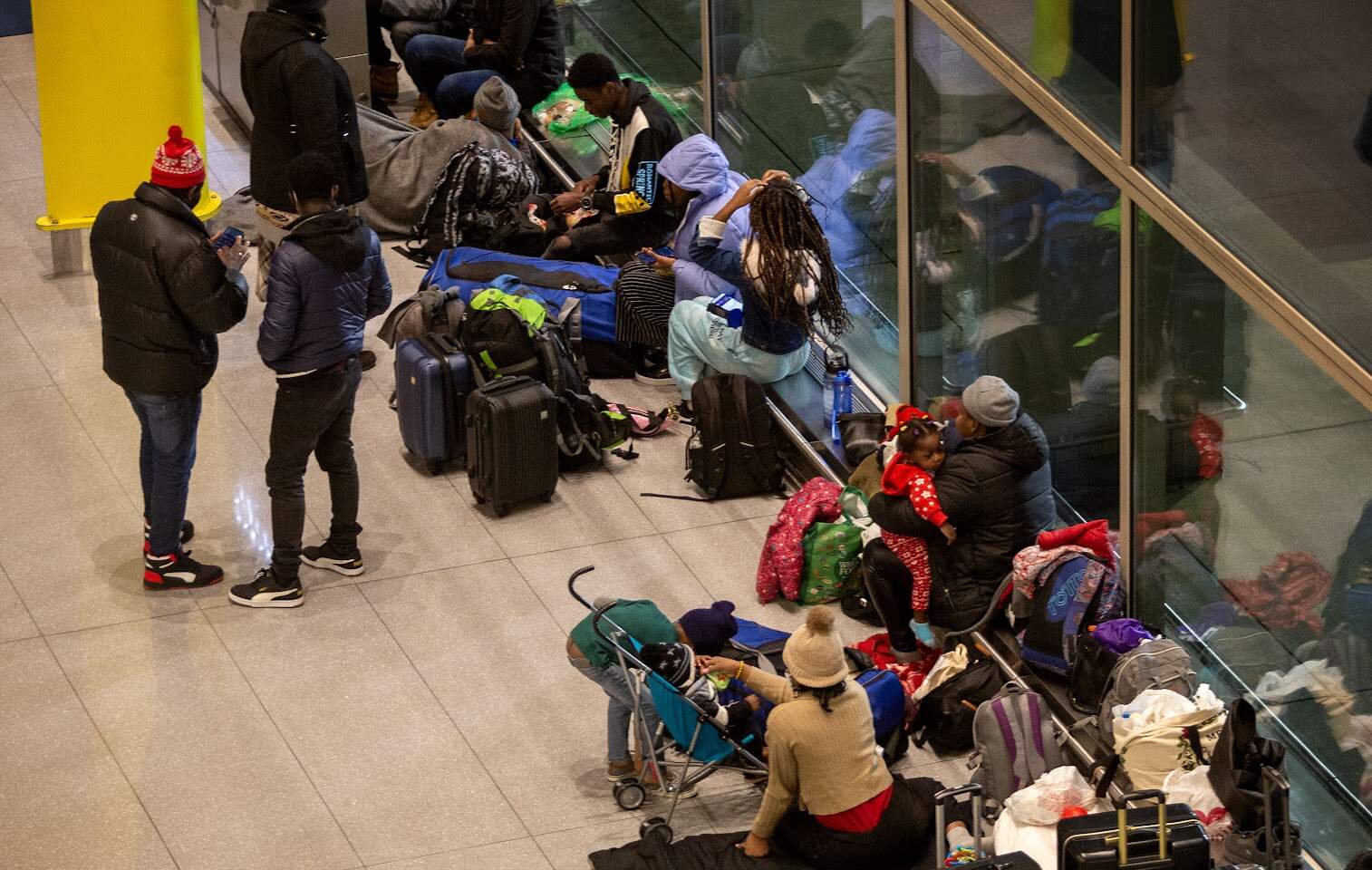 Families without without anywhere to stay, settle down for the night at Boston's Logan Airport on Jan. 29, 2024. (Robin Lubbock/WBUR)