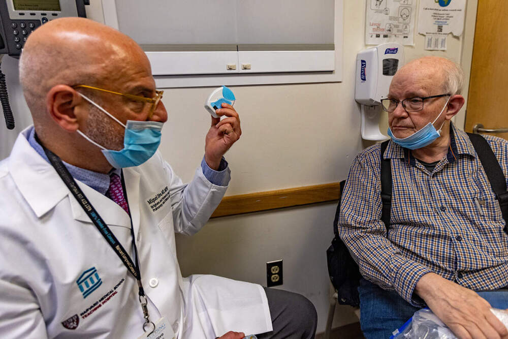 A doctor holds up a new inhaler about the size of a hockey puck that doesn't emit greenhouse gases when it's used.