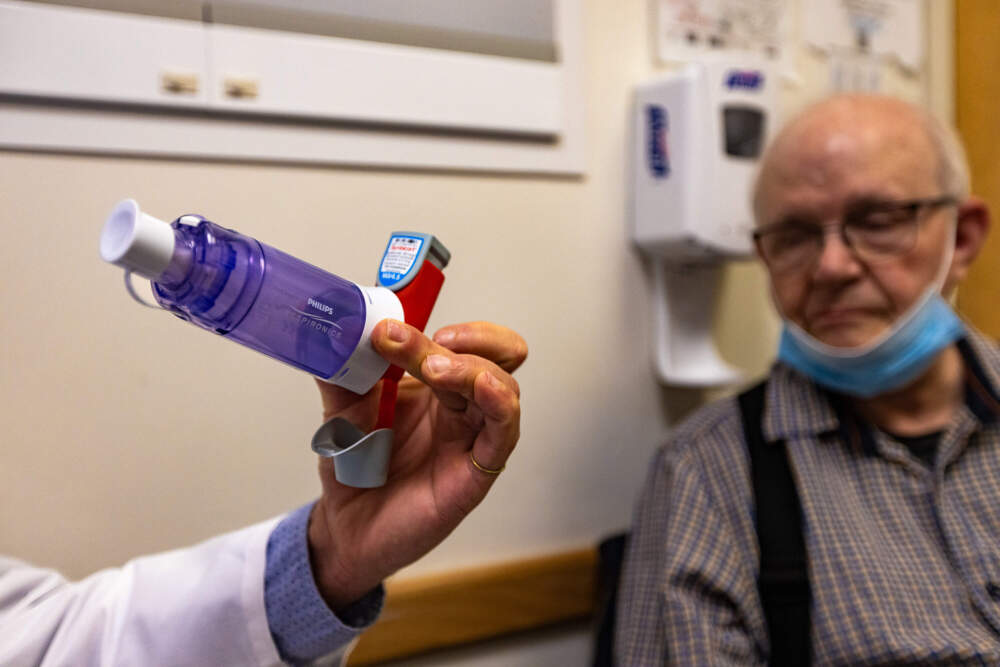 Dr. Miguel Divo, at Brigham and Women's Hospital, holds a metered-dose inhaler. Current versions release a greenhouse gas that's up to 3,000 times more potent than carbon dioxide. (Jesse Costa/WBUR)