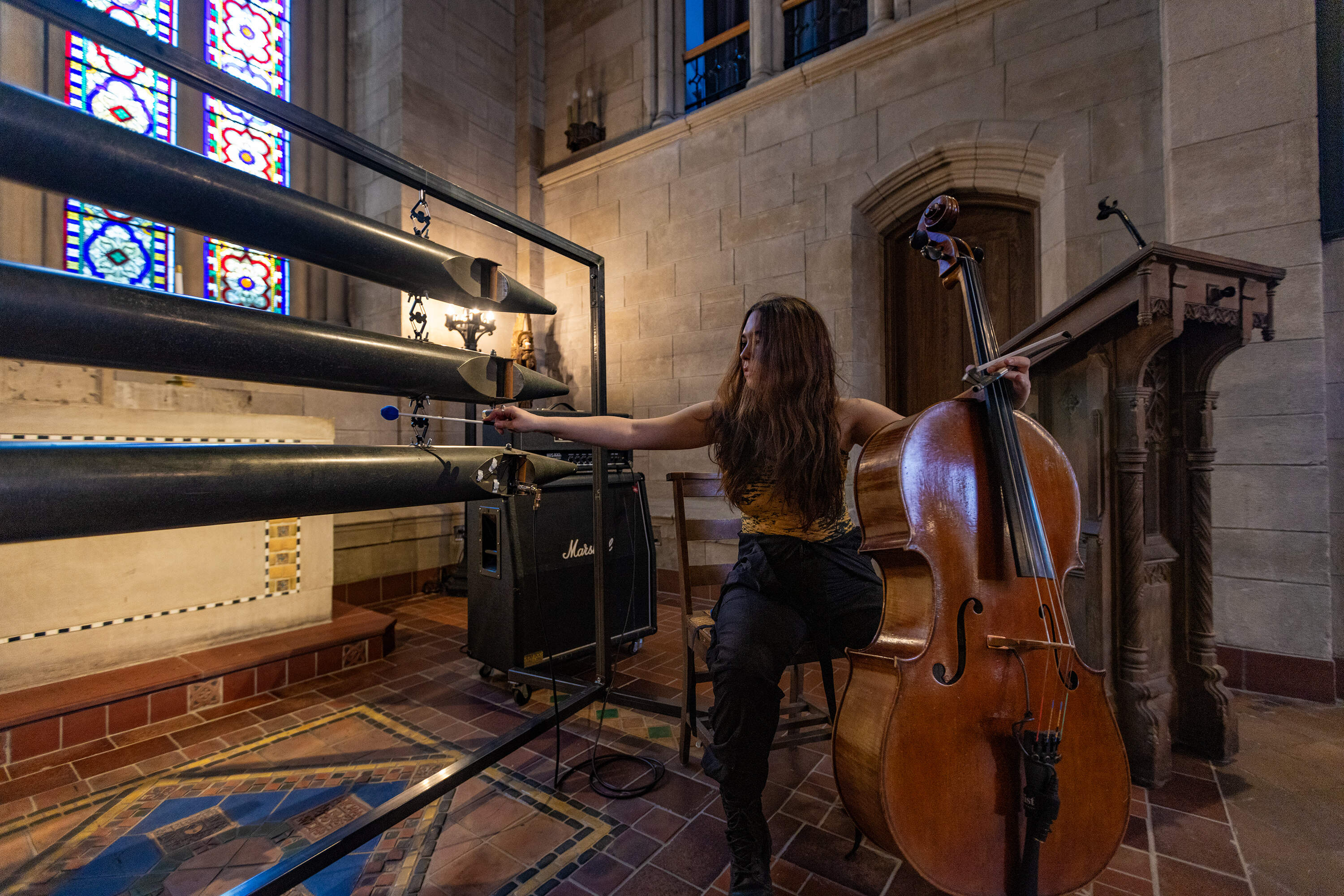 Artist-in-residence Eden Rayz plays the instrument "Argent and Sable" she built from the organ pipes recently removed from Bigelow Chapel. (Jesse Costa/WBUR)