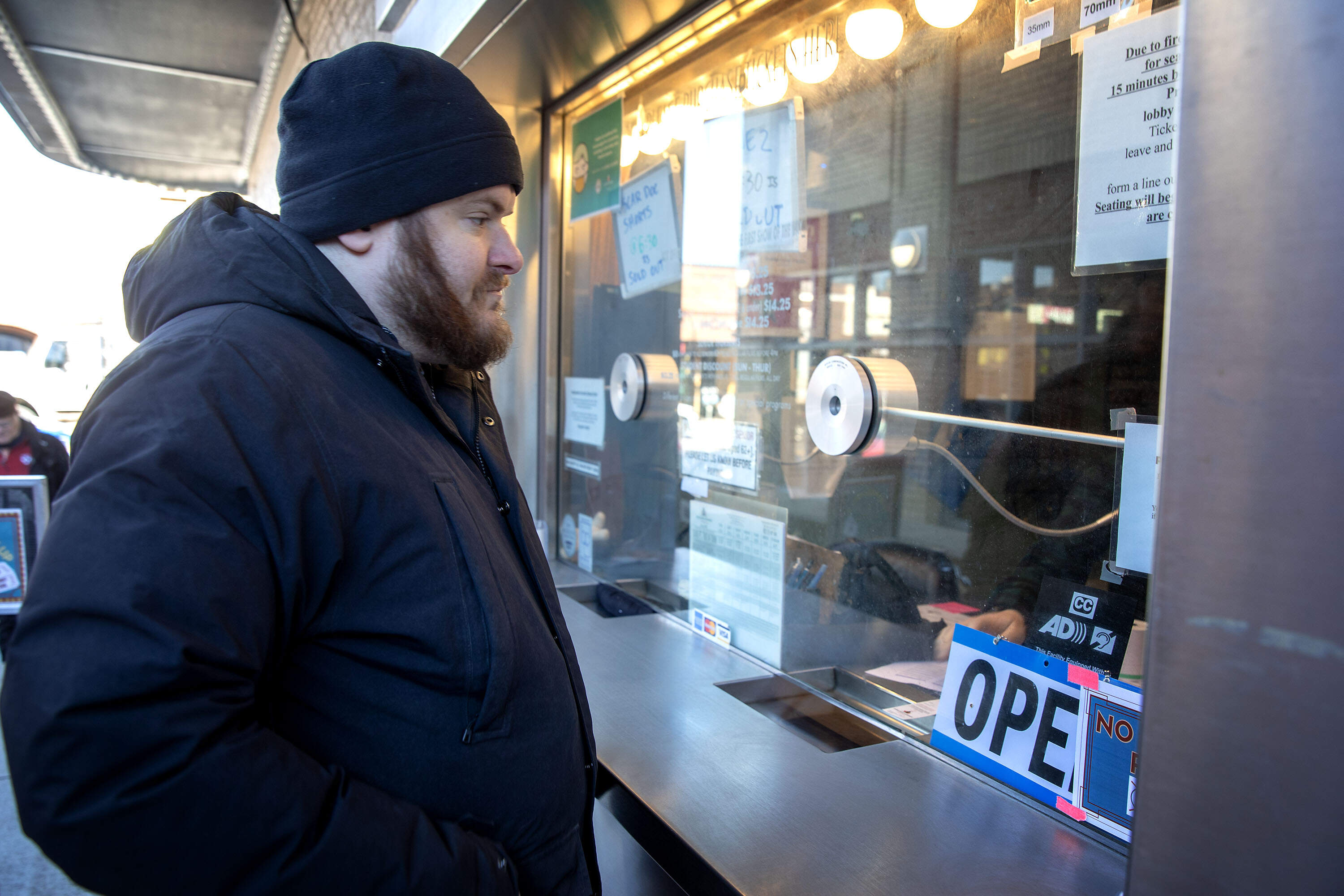 Andrew Bruss waits for his ticket at the old ticket window of The Coolidge Corner Theatre. (Robin Lubbock/WBUR)