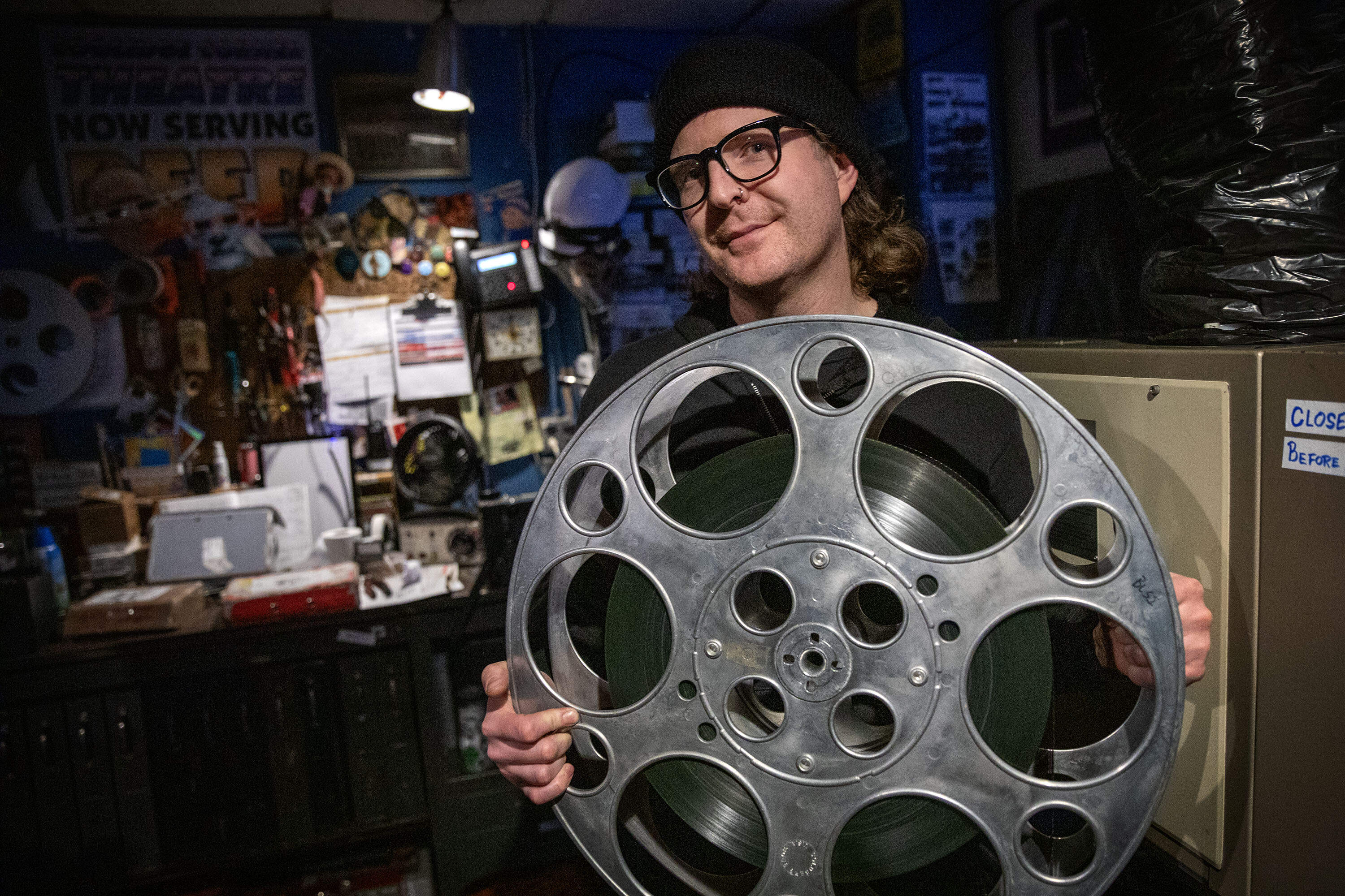 Lead Projectionist Thomas Welch holds a reel of 70mm film in the Moviehouse 1 projection room at the Coolidge Corner Theatre. (Robin Lubbock/WBUR)