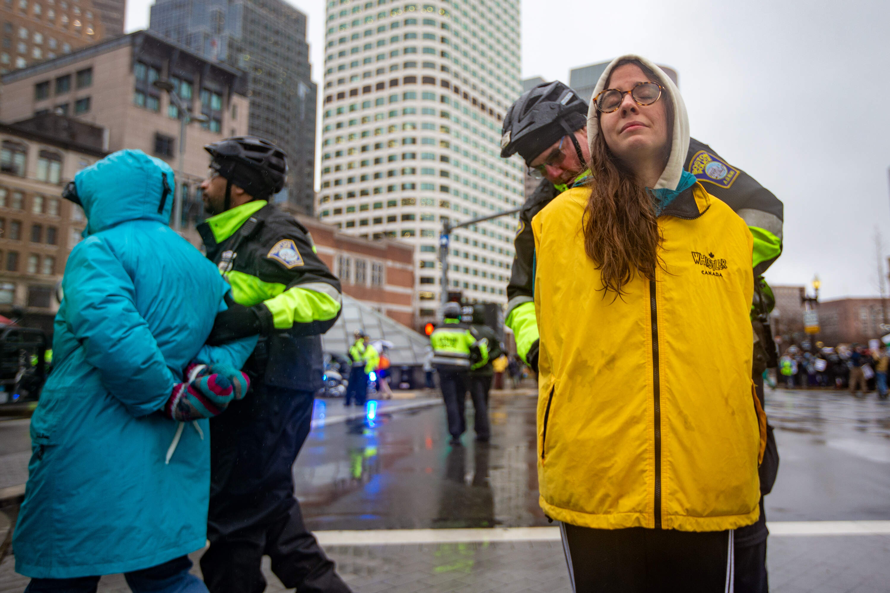 Police cuff a protester as a second officer arrests another demonstrator for blocking the intersection of Summer Street and Atlantic Avenue in an act of civil disobedience to protest Israel's war in Gaza. (Jesse Costa/WBUR)