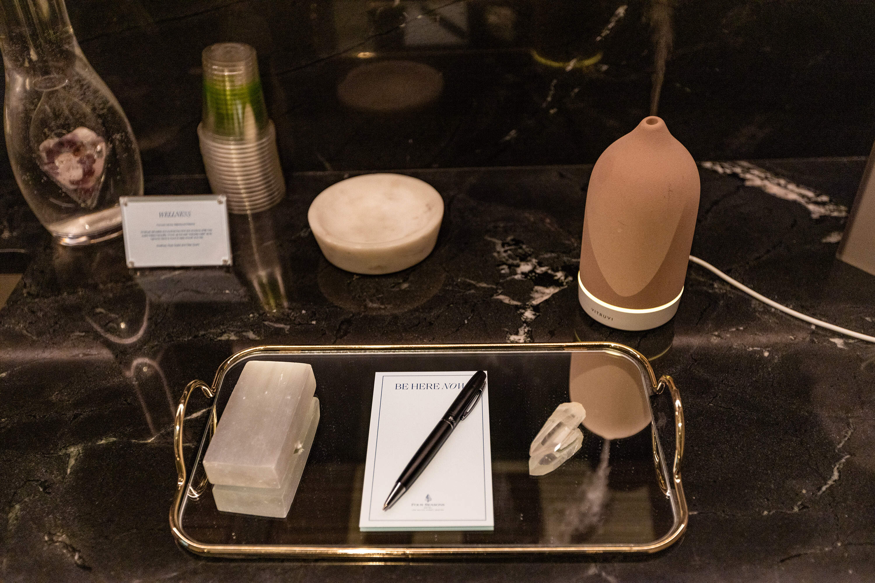 A platter containing crystals and a card is for writing down your intensions. as well as an aromatherapy diffuser are used in the treatment room at the Spa at One Dalton. (Jesse Costa/WBUR)