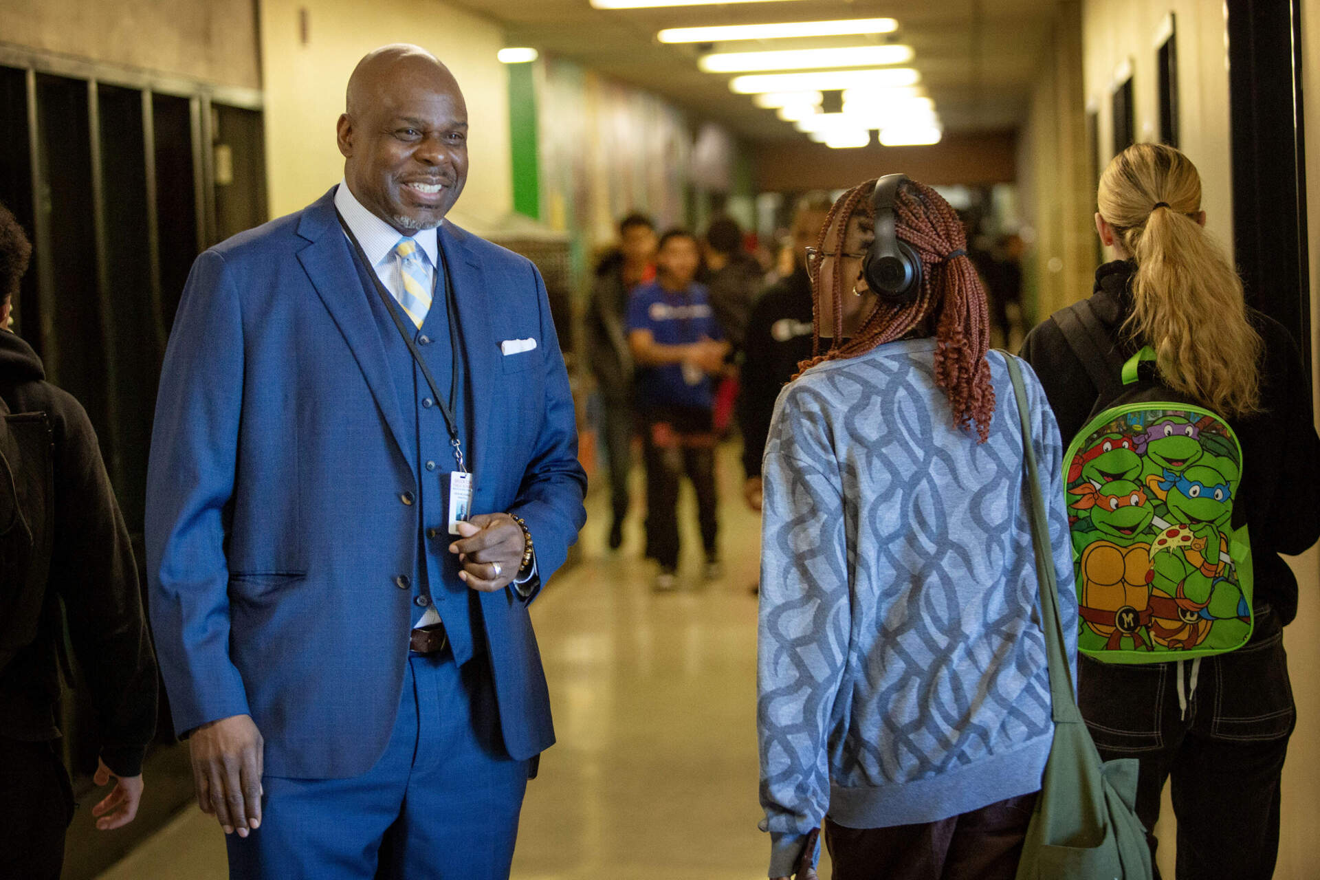 Principal Kevin McCaskill talks with students walking the hallways between classes. (Robin Lubbock/WBUR)