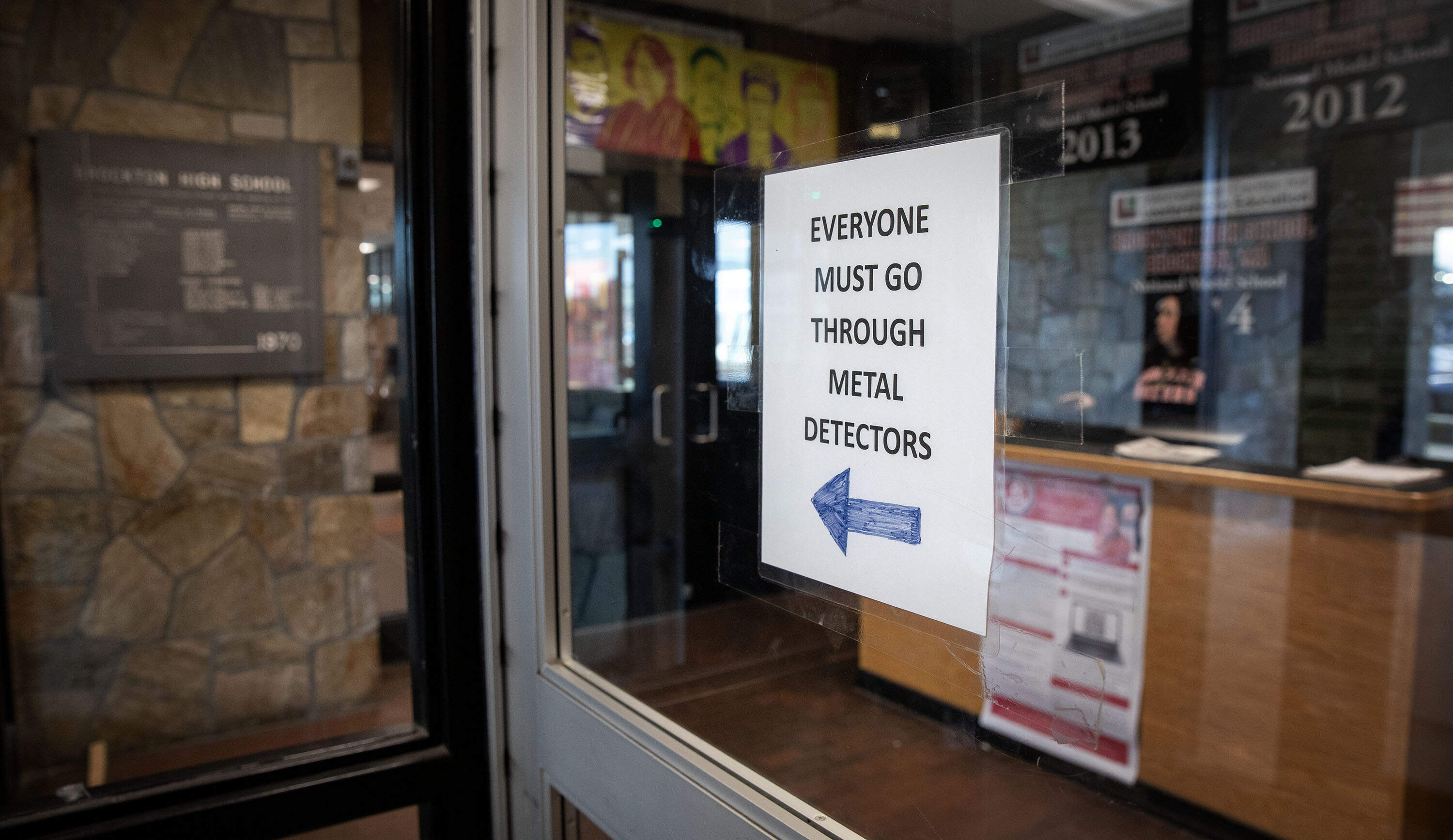 A sign at the main entrance to Brockton High requires people entering the school to pass through a metal detector. (Robin Lubbock/WBUR)