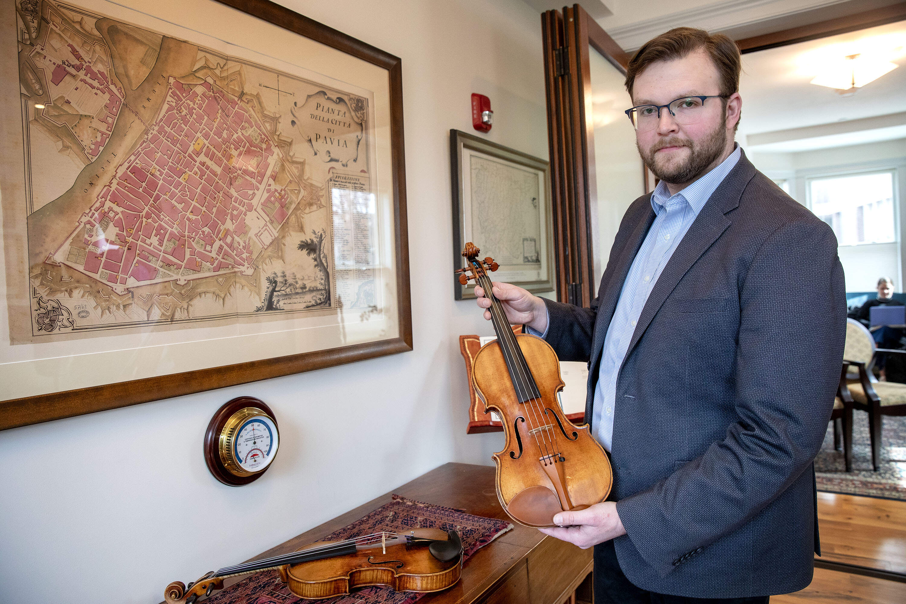Ken Cox, sales manager at Reuning &amp; Son Violins, gently holds an Antonio Stradivari violin made around 1702. (Robin Lubbock/WBUR)