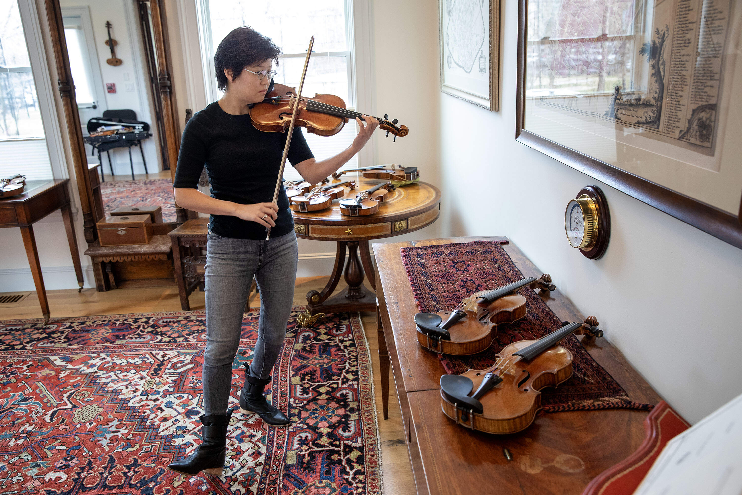 Violinist Clara Kim plays a Giovanni Battista Guadagnini violin made in Turin in 1783, at Reuning &amp; Son Violins, as she make her selection of a fine violin for A Far Cry's &quot;Stradivari Serenade.&quot; (Robin Lubbock/WBUR)