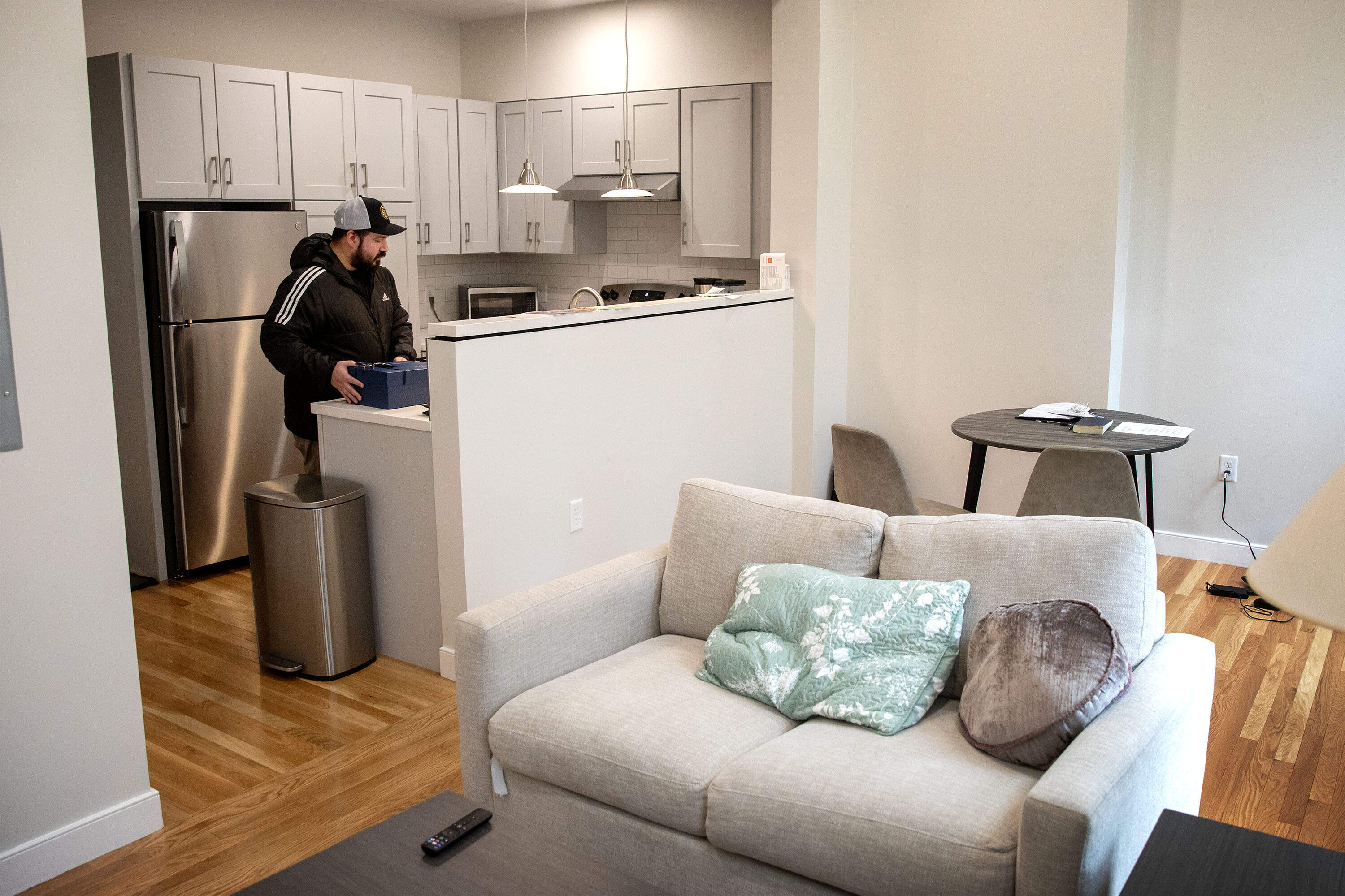 Army veteran Tony Magnole sets down the gift box he received from Mayor Michelle Wu in his new apartment in Boston's South End. (Robin Lubbock/WBUR)