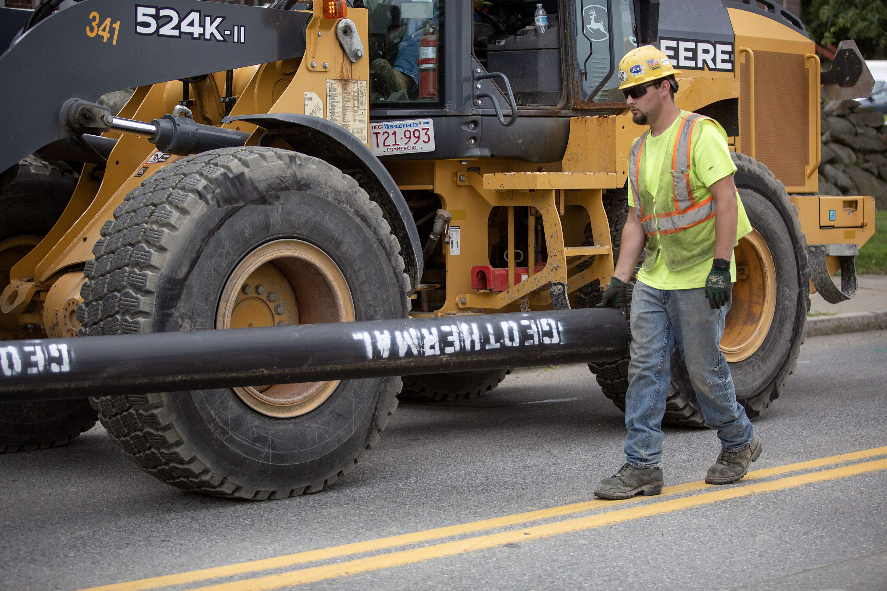 Workers move a geothermal pipe along Normandy Road in Framingham. (Robin Lubbock/WBUR)