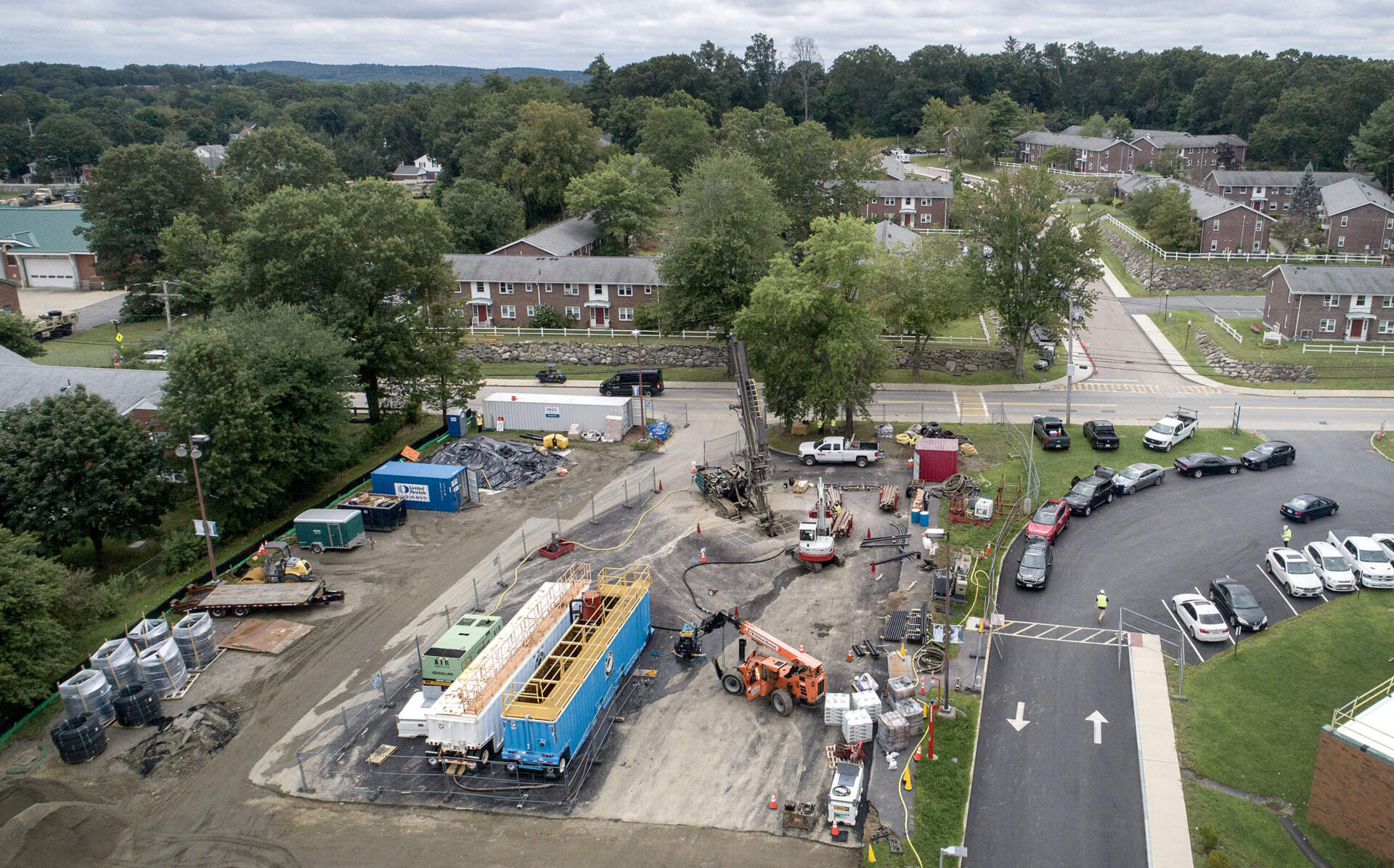 A drill bores geothermal wells near the Rose Kennedy Lane housing complex in Framingham. (Robin Lubbock/WBUR)