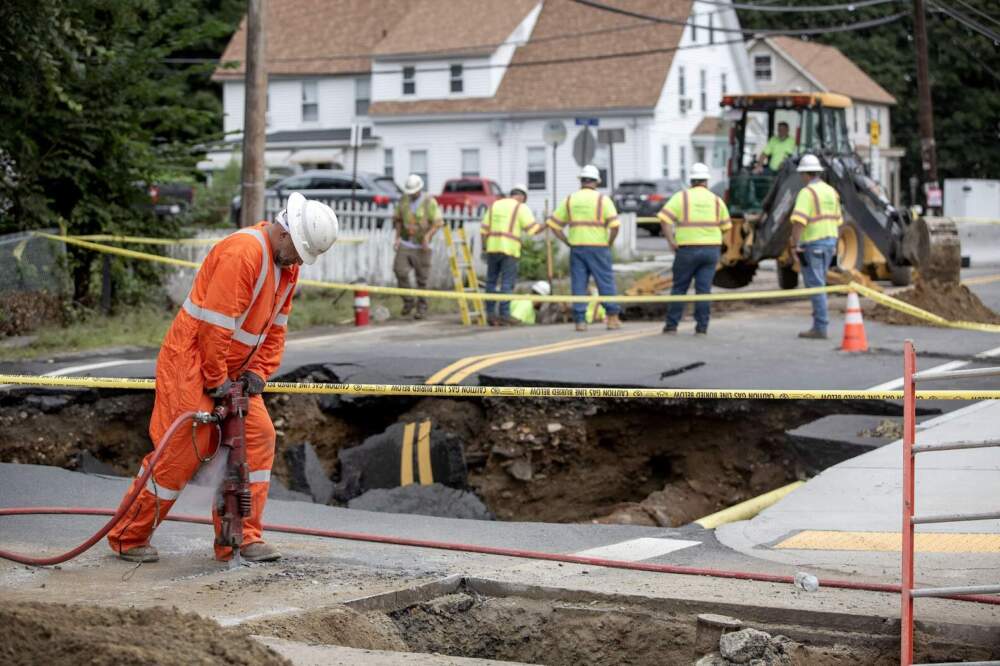 Workers begin repair work on a section of Chestnut Street in Leominster, where flood waters swept away the road on September 11. (Robin Lubbock/WBUR)