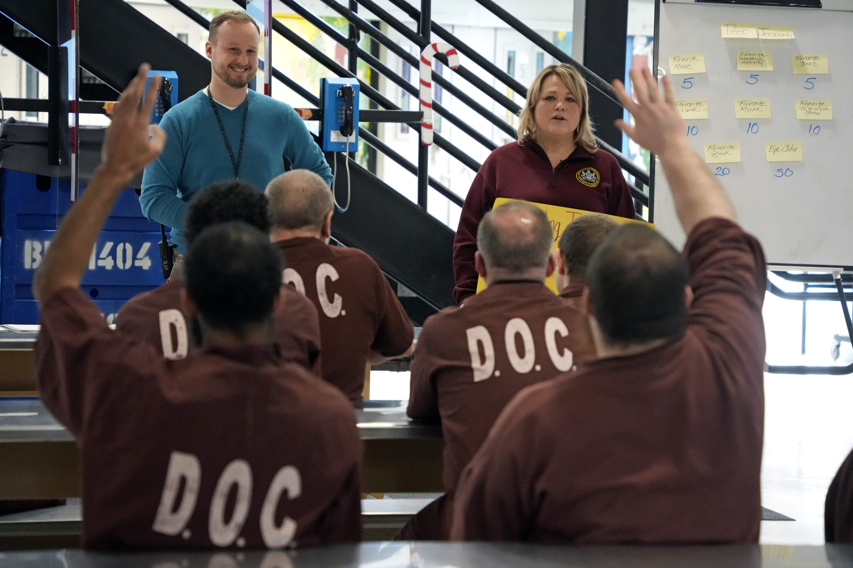 Prison psychological specialists Christine Ransom, top right, and Randy Kulesza, top left, lead a group session for inmates, Dec. 14, 2023, in the Neurodevelopmental Residential Treatment Unit at Pennsylvania's State Correctional Institution in Albion, Pa. The prison unit is helping men with autism and their intellectual and developmental disabilities stay safe behind bars while learning life skills. The unit is the first in the state and one of only a handful nationwide. (Gene J. Puskar/AP)