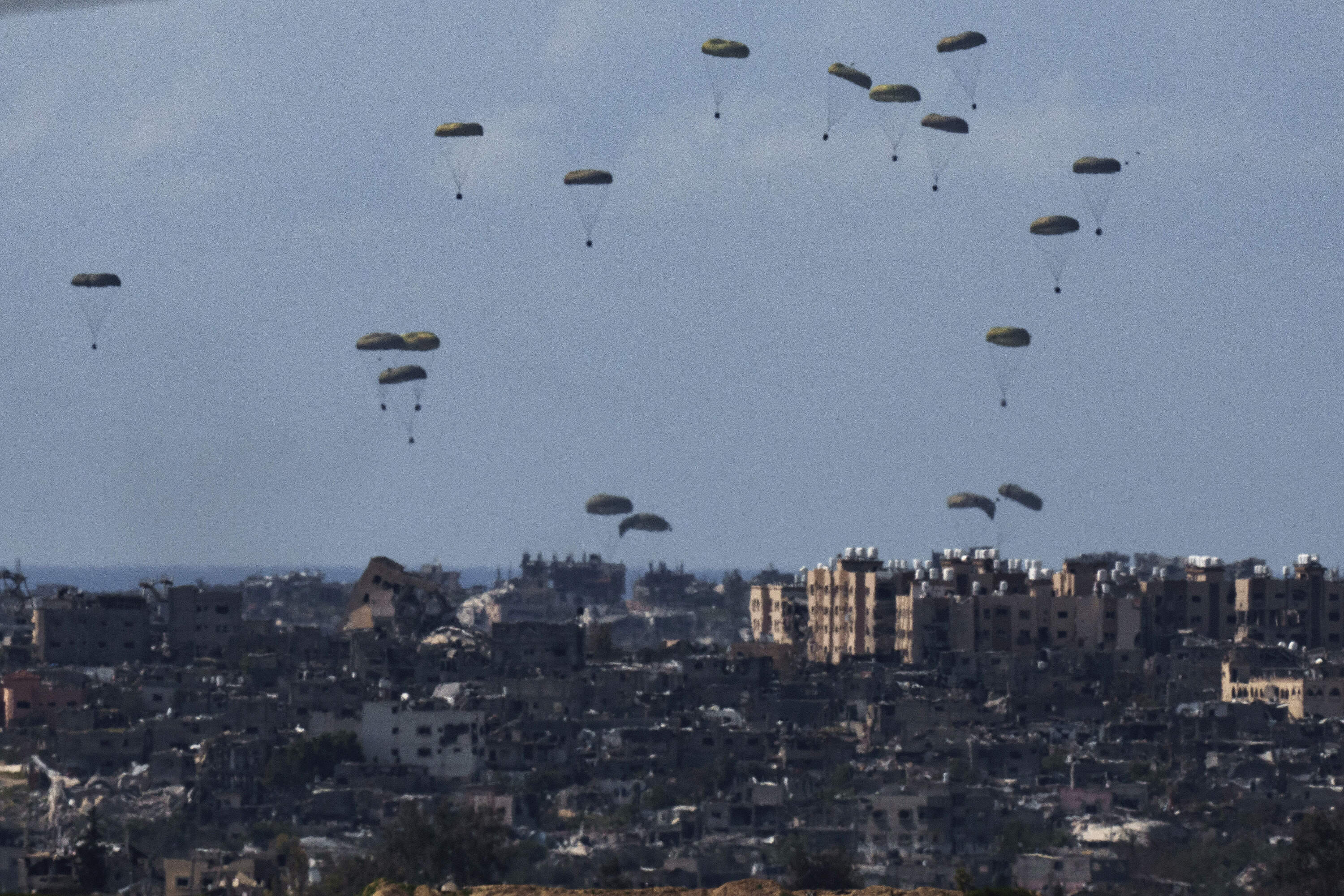Parachutes drop supplies into the northern Gaza Strip. (Leo Correa/AP)