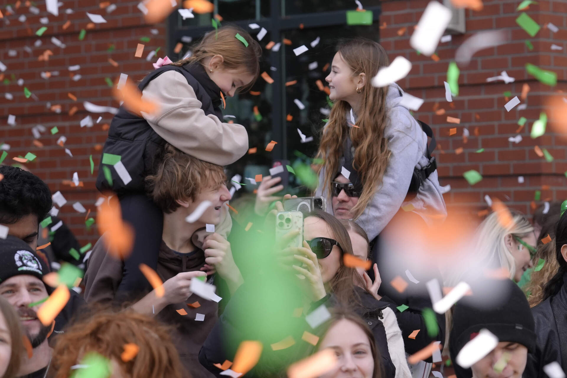 People are blanketed with falling confetti during opening ceremonies for the 2014 St. Patrick's Day parade in South Boston. (Steven Senne/AP)