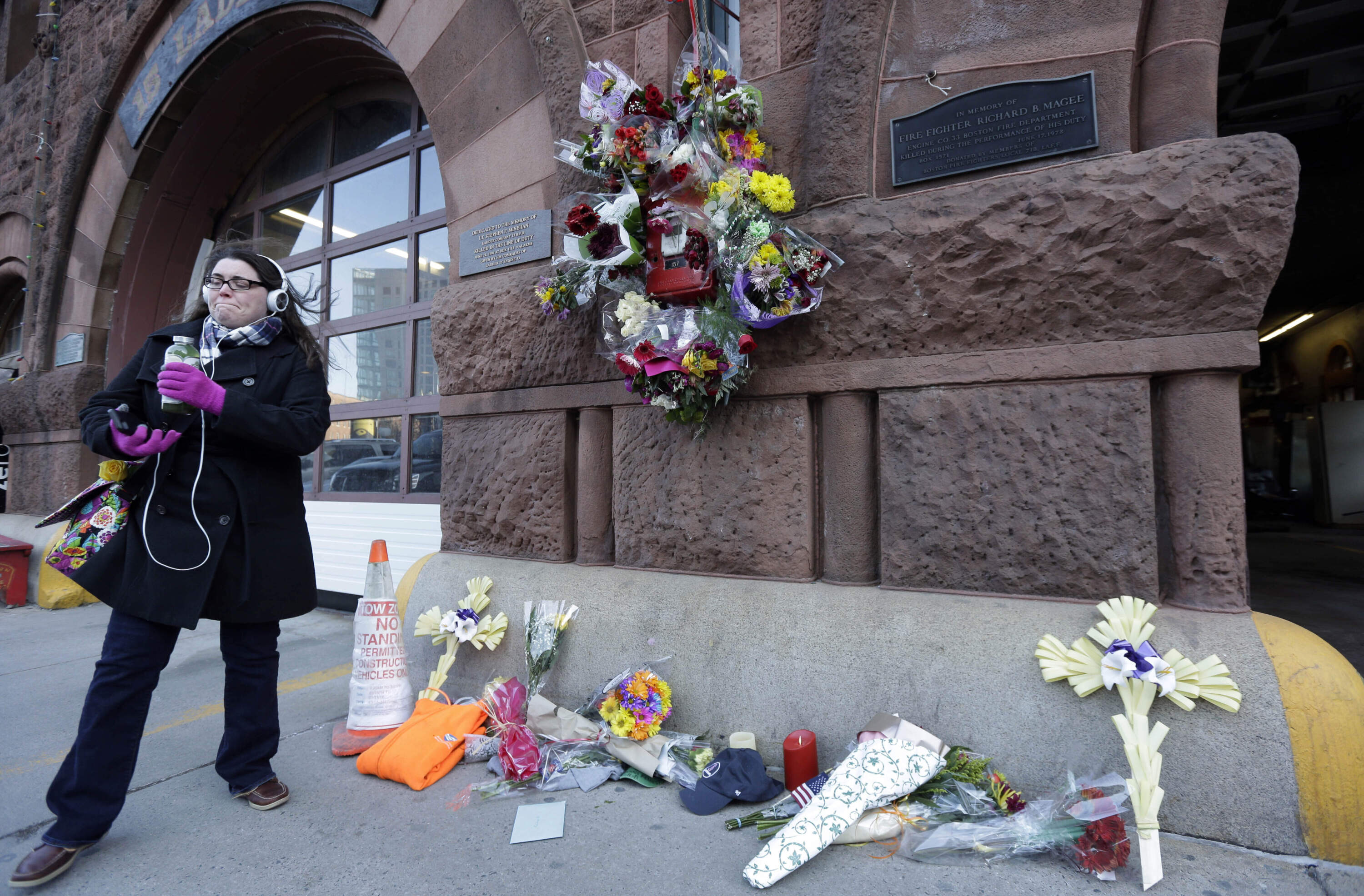 Flowers pile up at a makeshift memorial in the front of fire station Engine 33/Ladder 15, March 27, 2014, in Boston. Engine 33/Ladder 15 was the station of fallen firefighters Lt. Edward Walsh and Michael Kennedy. (Steven Senne/AP)